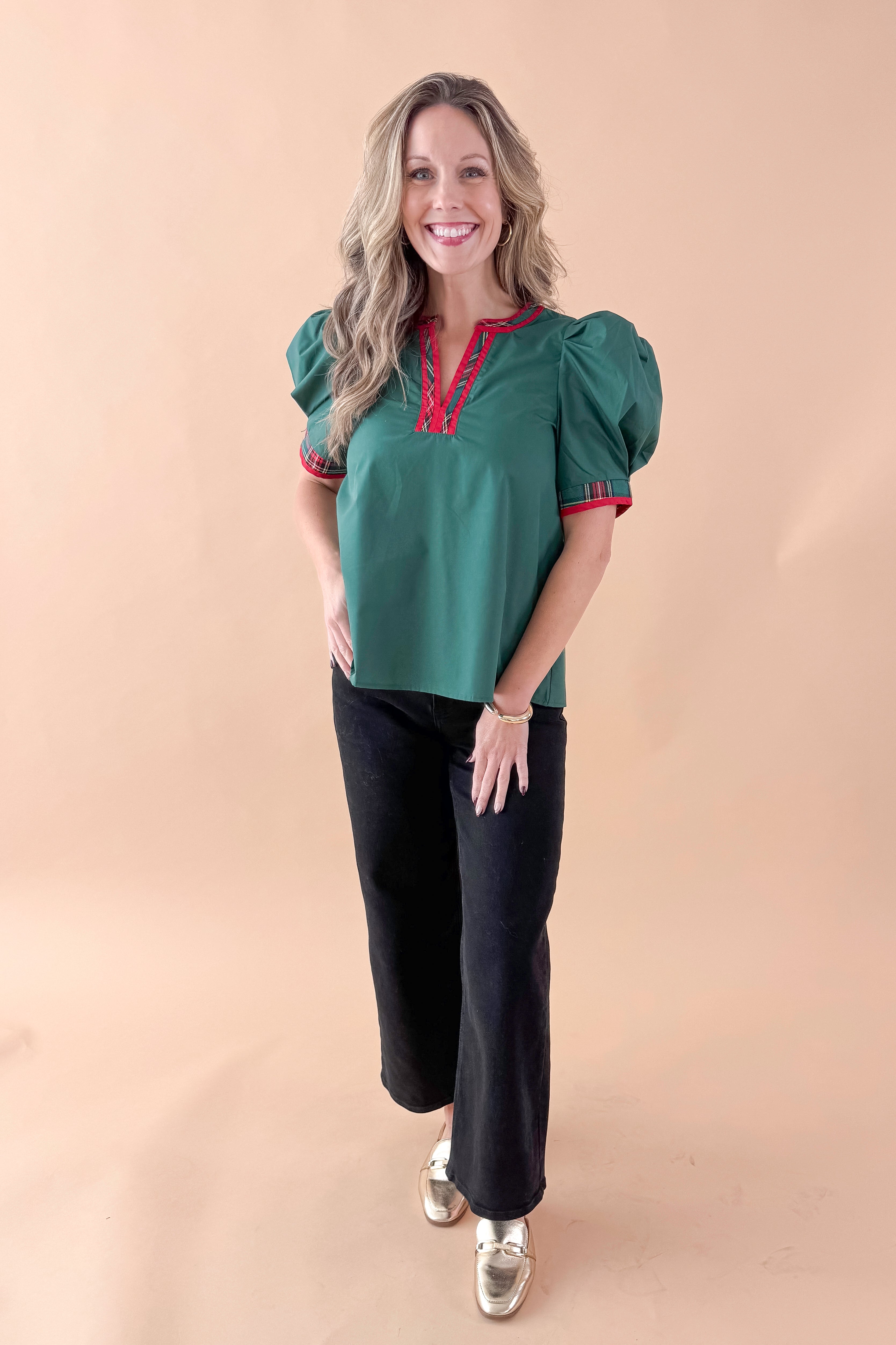 Front view of woman wearing Green With Tartan Lining Puff Sleeve Top with jeans against tan studio background.