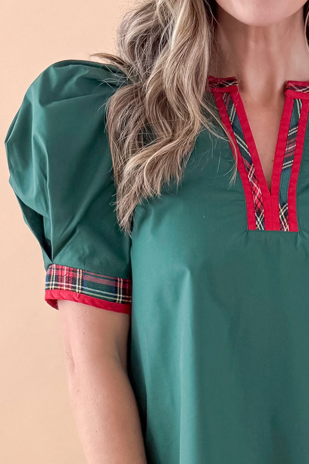 Front detailed view of woman wearing Green With Tartan Lining Puff Sleeve Top against tan studio background.