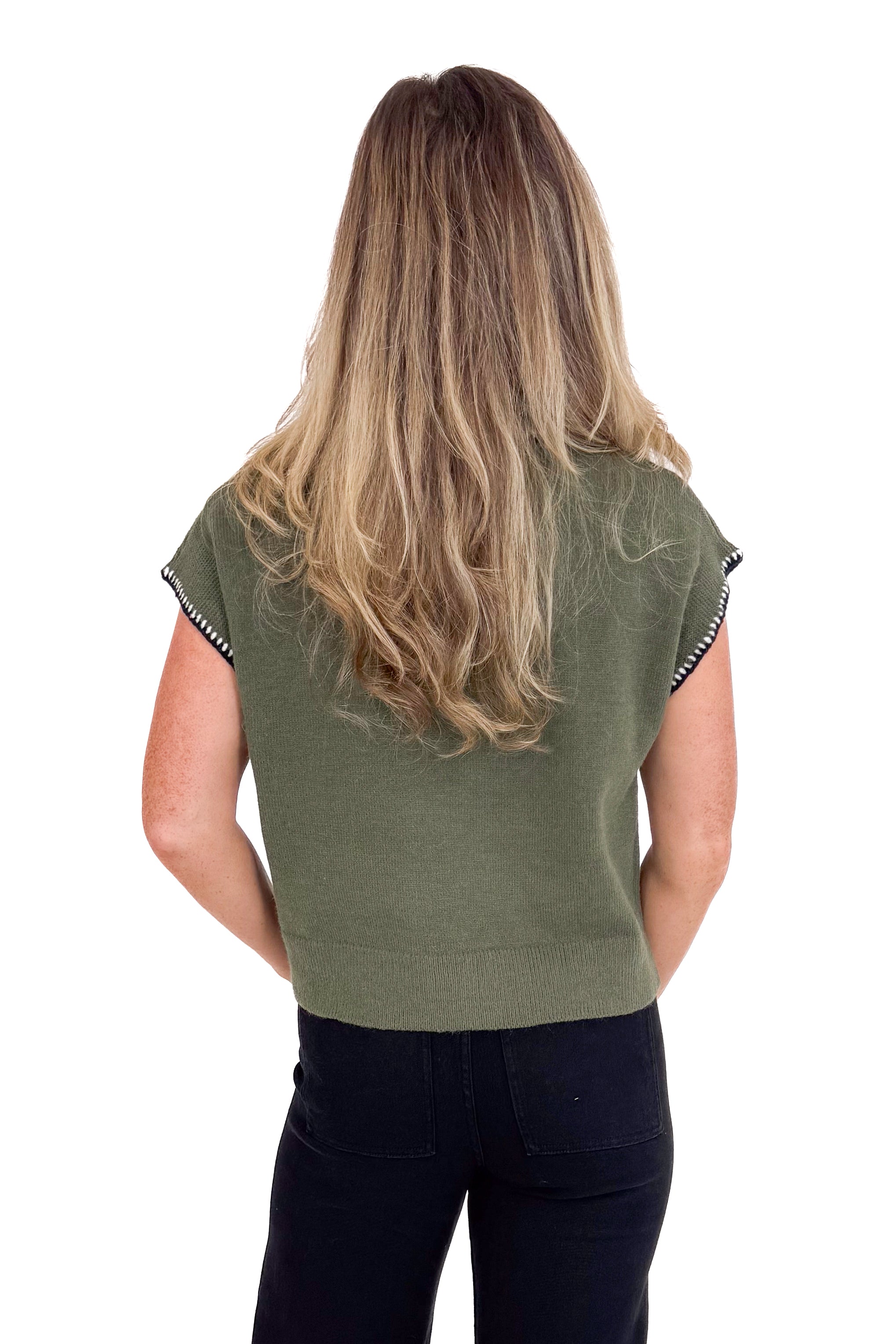 Person wearing a green sleeveless top with black trim on a white background