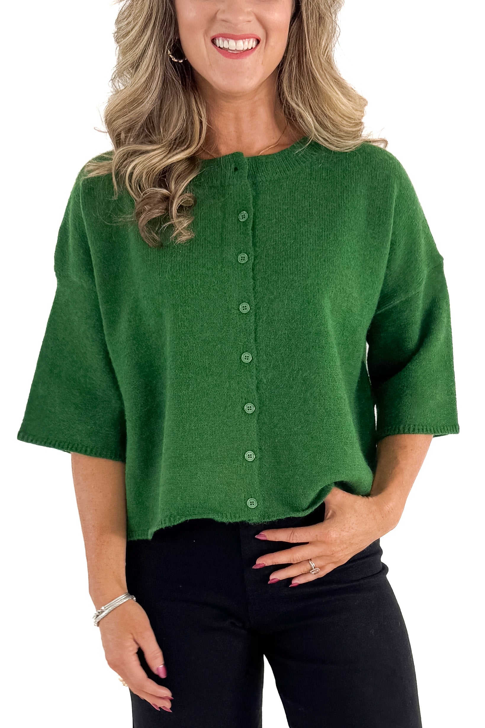 Front detailed view of woman wearing green sweater with jeans against white studio background.