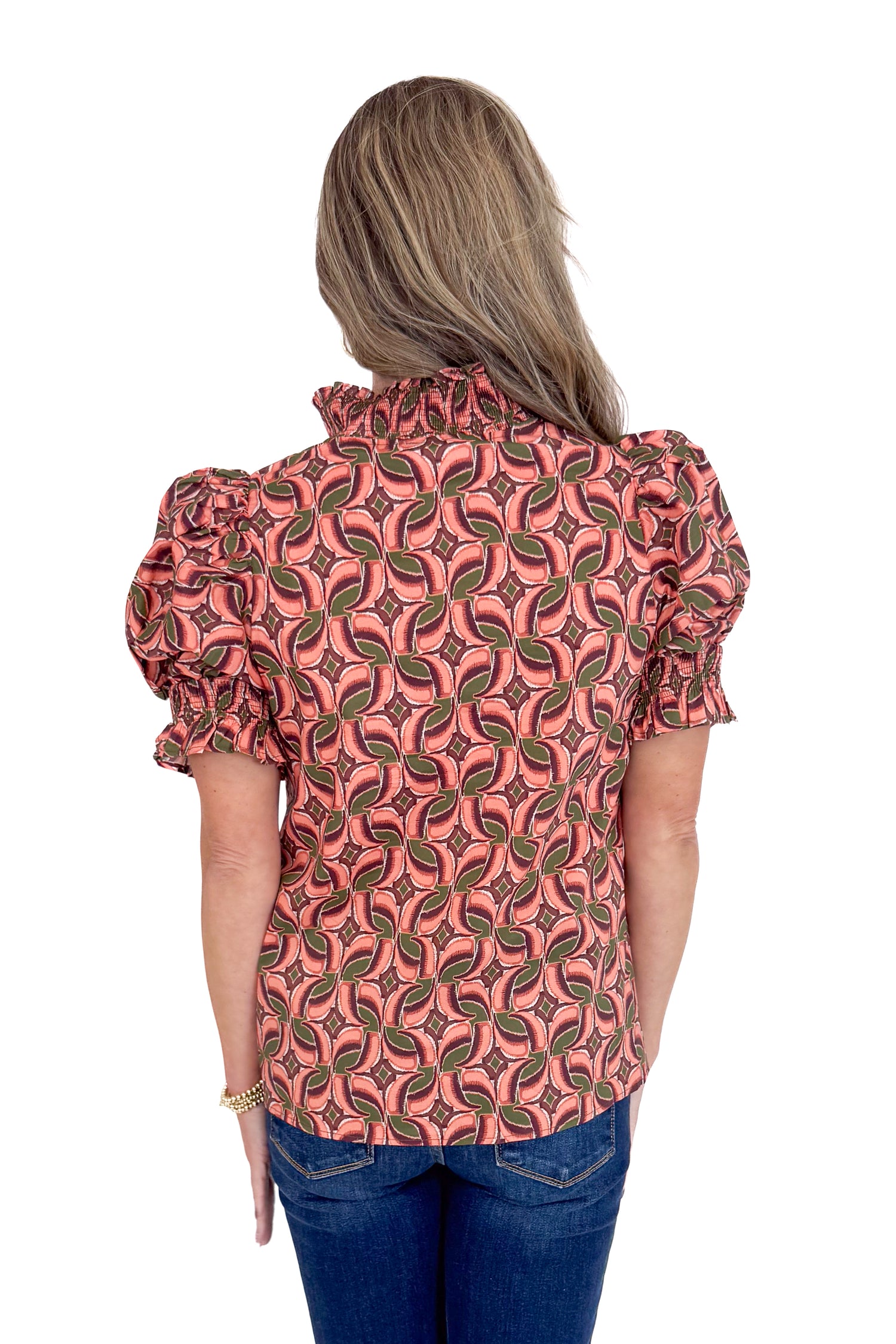 Woman wearing a patterned blouse with puff sleeves on a white background