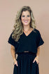 Woman wearing a black outfit with a plain background