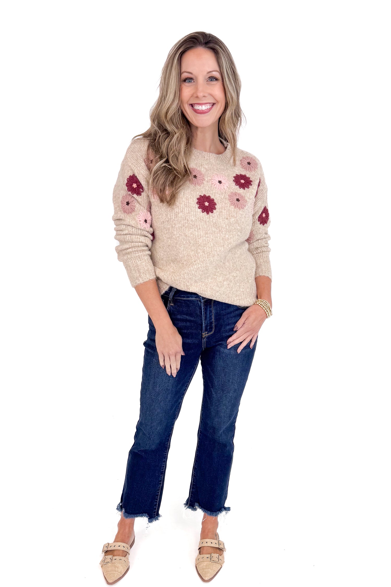 Woman wearing a floral sweater and jeans on a white background