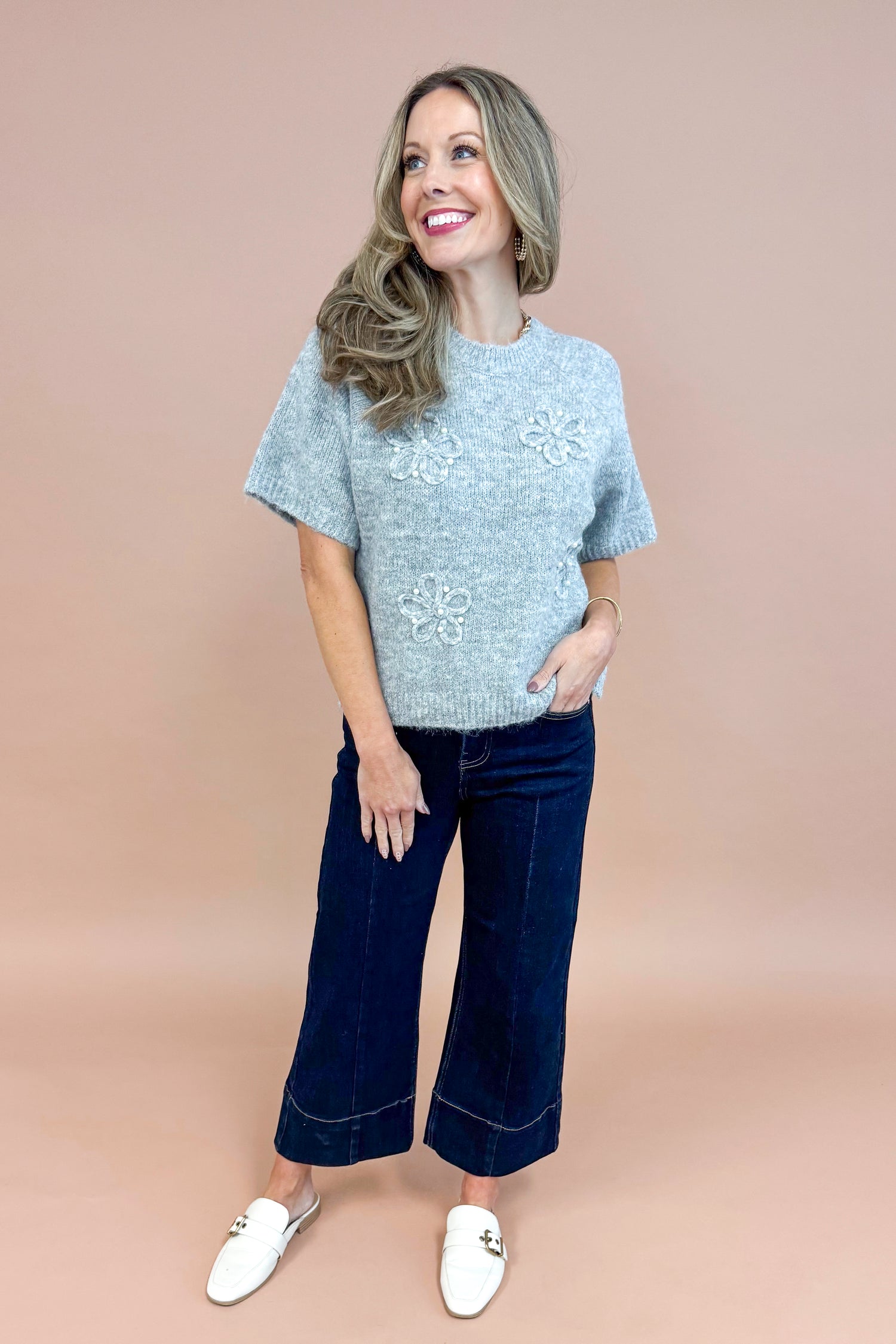 Front view of woman wearing Grey Floral & Pearl Detail Short Sleeve Sweater by Entro and blue jeans.