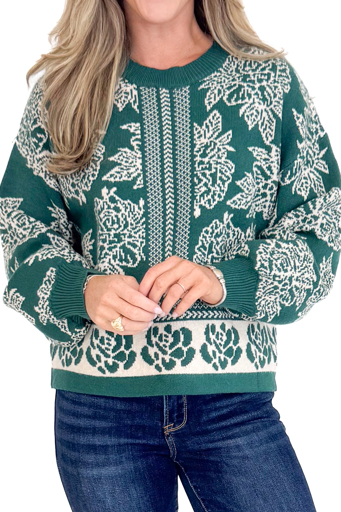 Person wearing a green sweater with white floral patterns on a white background