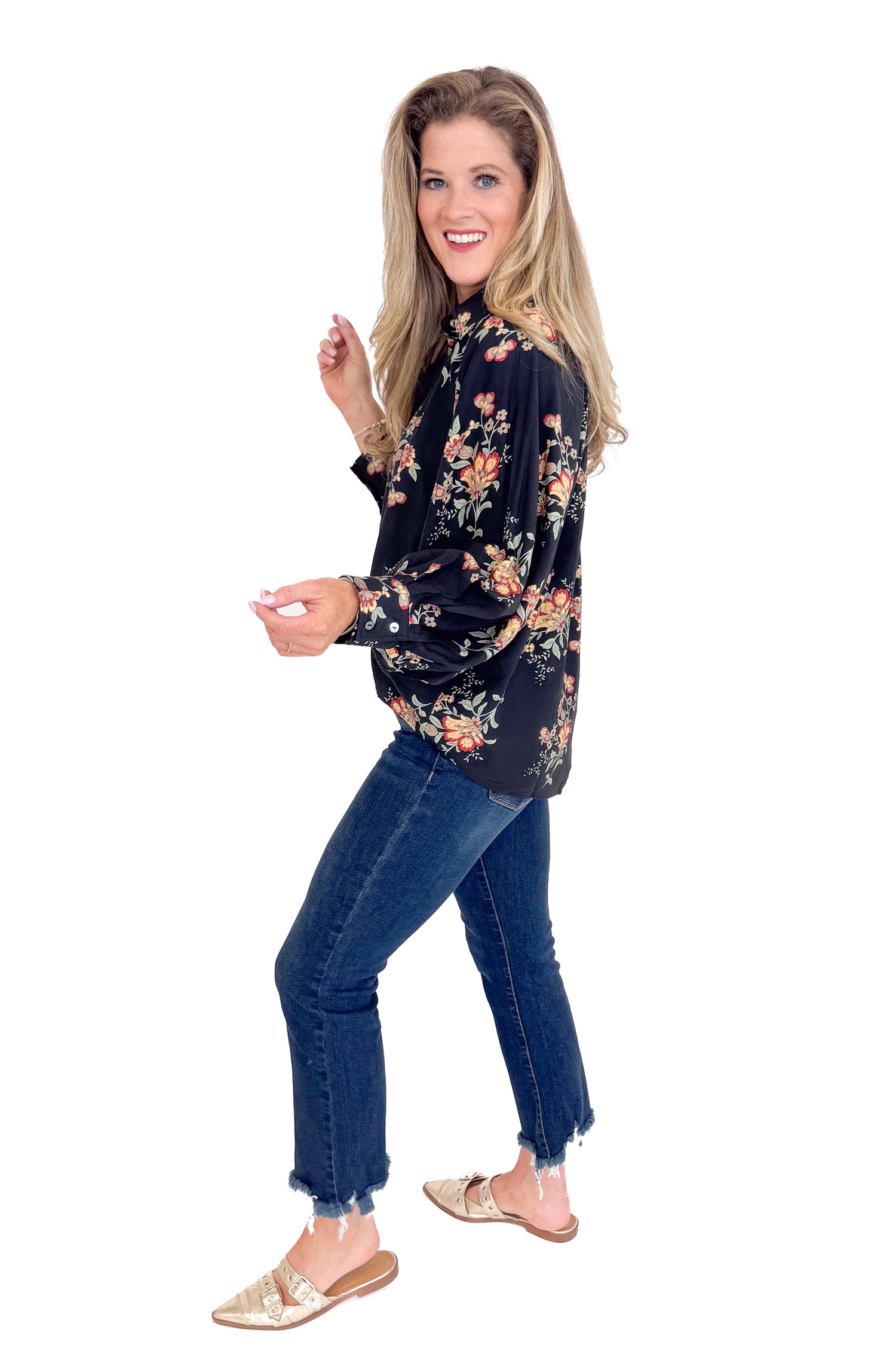 Woman wearing a floral blouse and jeans on a white background