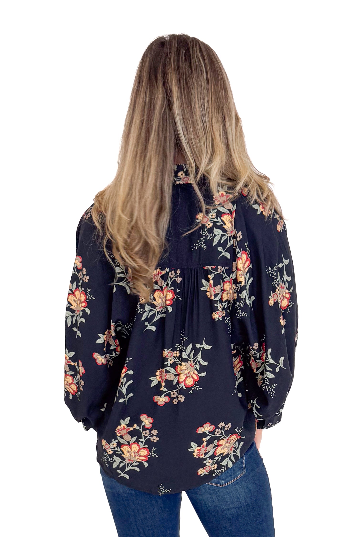 Person wearing a navy floral blouse on a white background