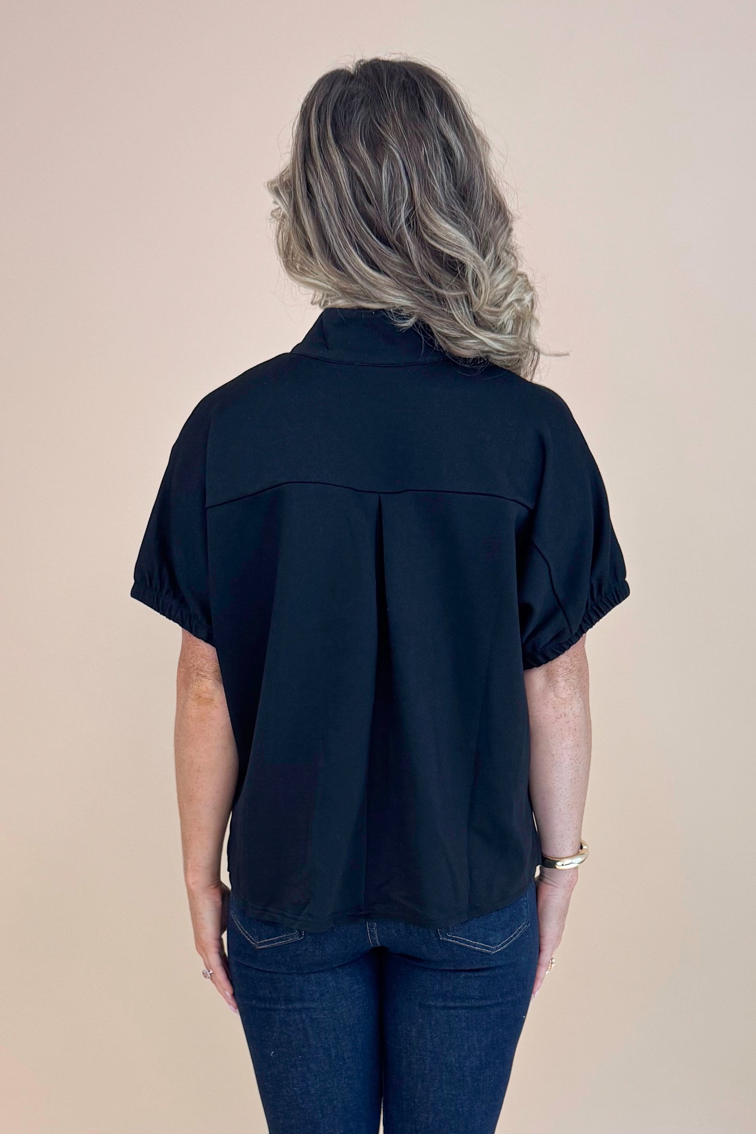 Rear view of Black Collared V-neck Top by Entro and blue jeans.