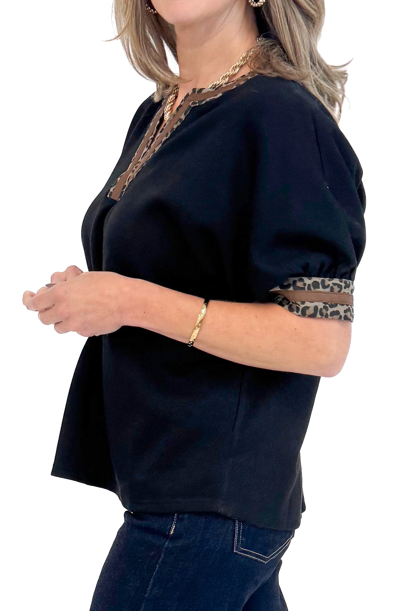 Side close up view of woman wearing a Black Leopard Lined V-neck Top by Entro.
