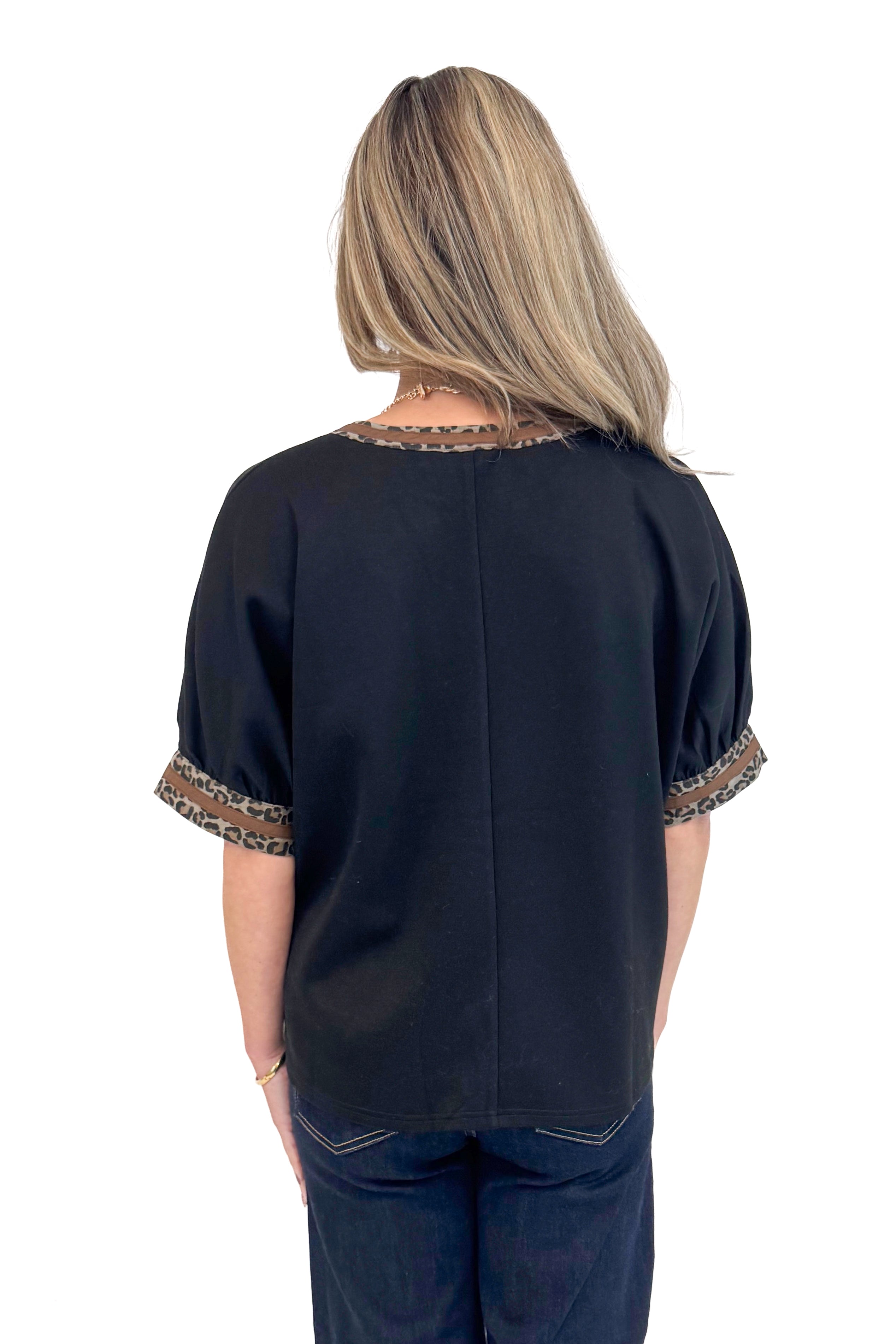 Back photo of woman wearing a Black Leopard Lined V-neck Top by Entro.