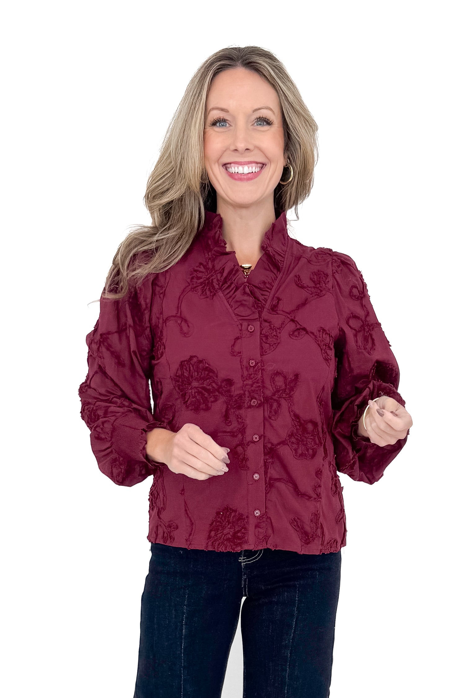 Front view of woman wearing button down top with jeans against white studio background.
