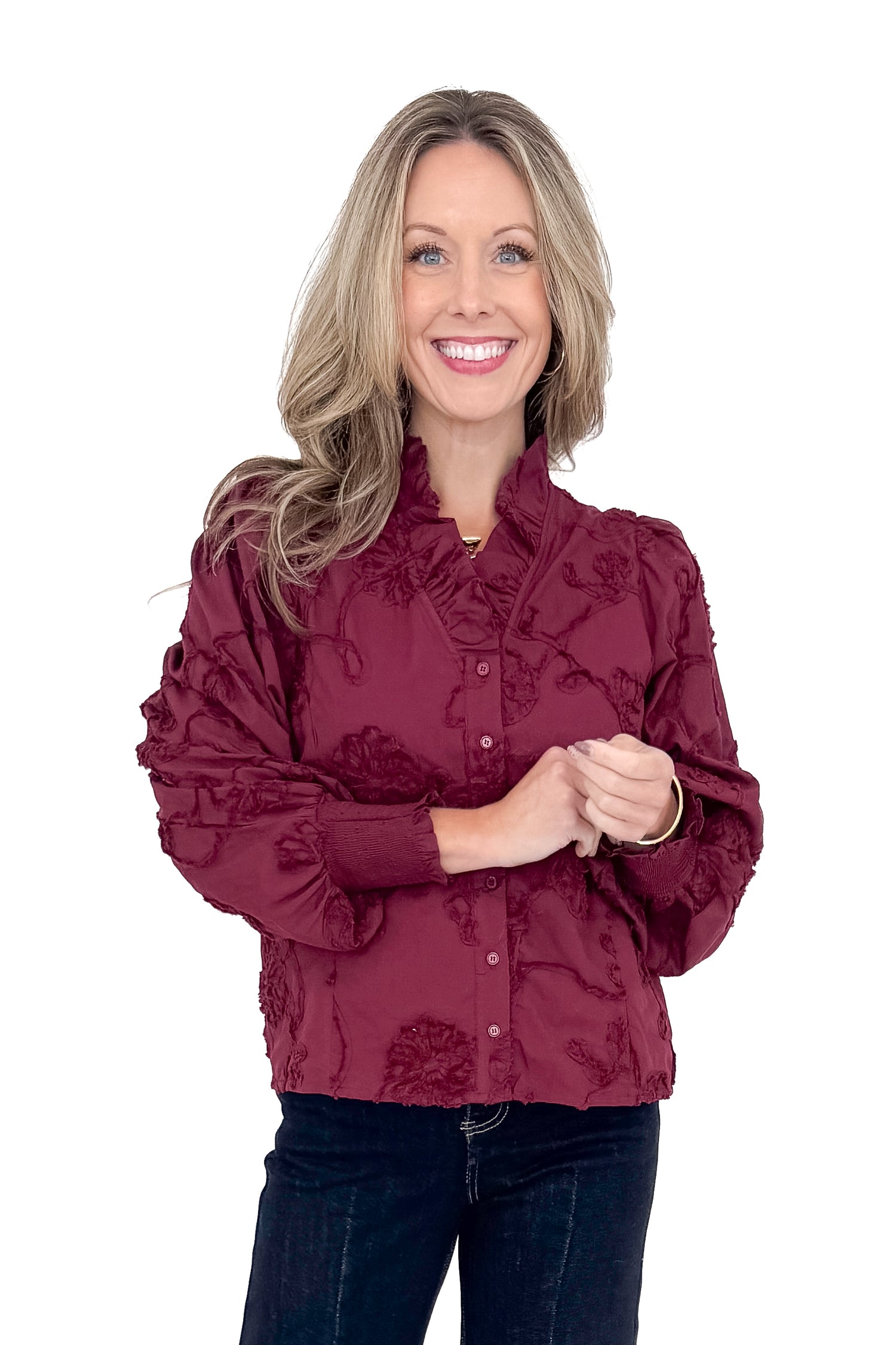 Front view of woman wearing button down top with jeans against white studio background.