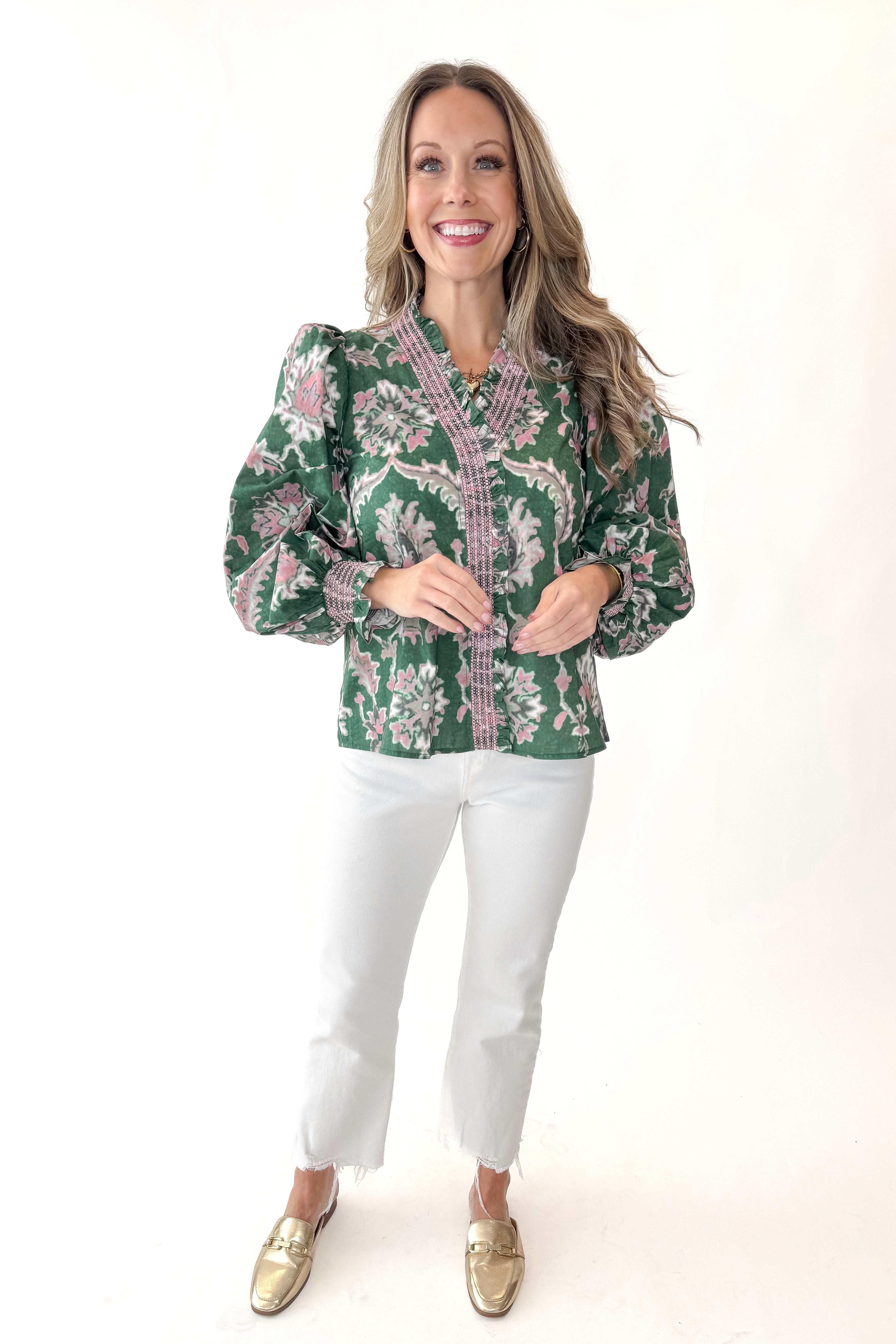 Front view of woman wearing Green & Pink Printed Smocked Center Top with jeans against white studio background.