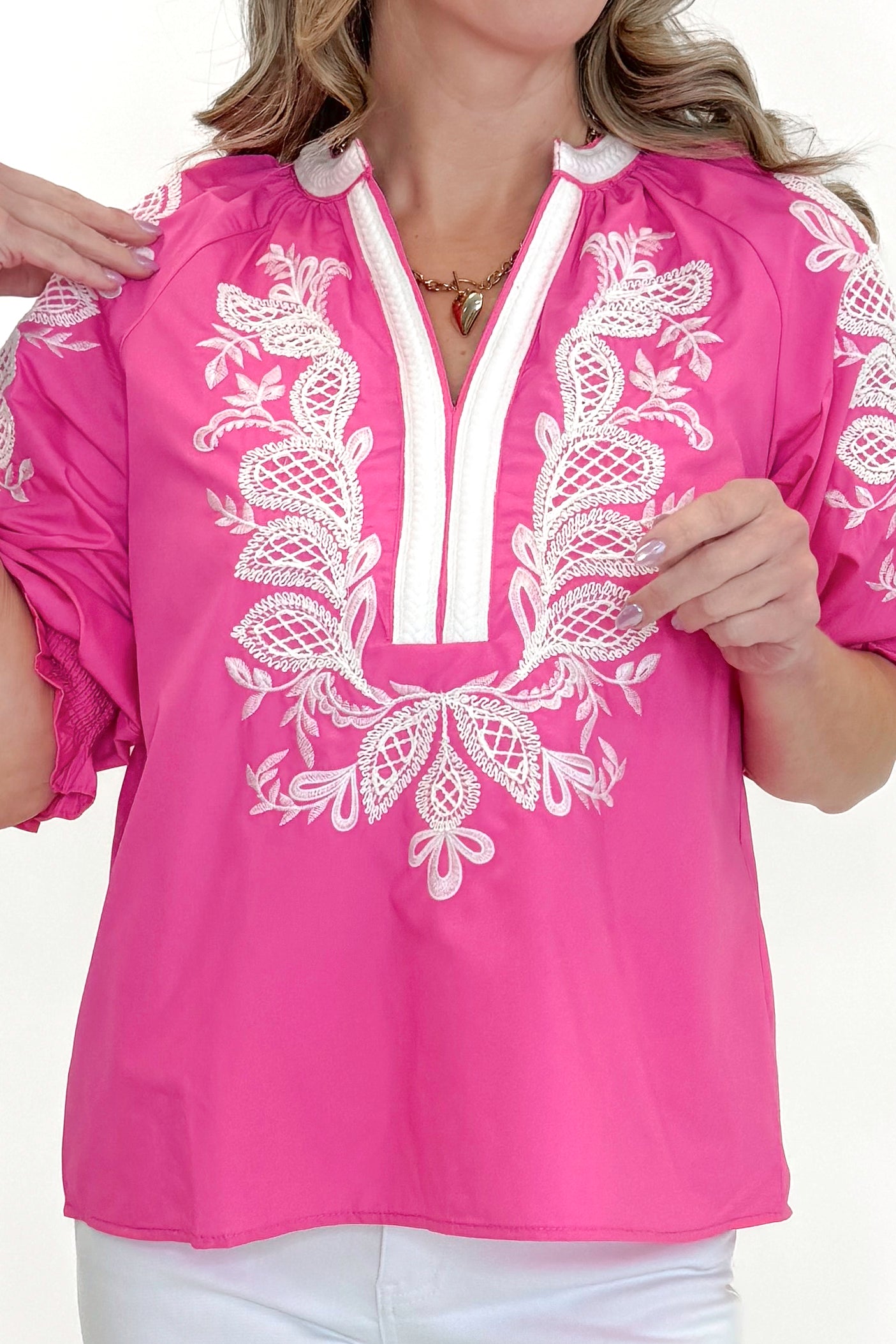 Front detail view of woman wearing Pink & White Embroidered 3/4 Sleeve Top by Entro with jeans against white studio background.