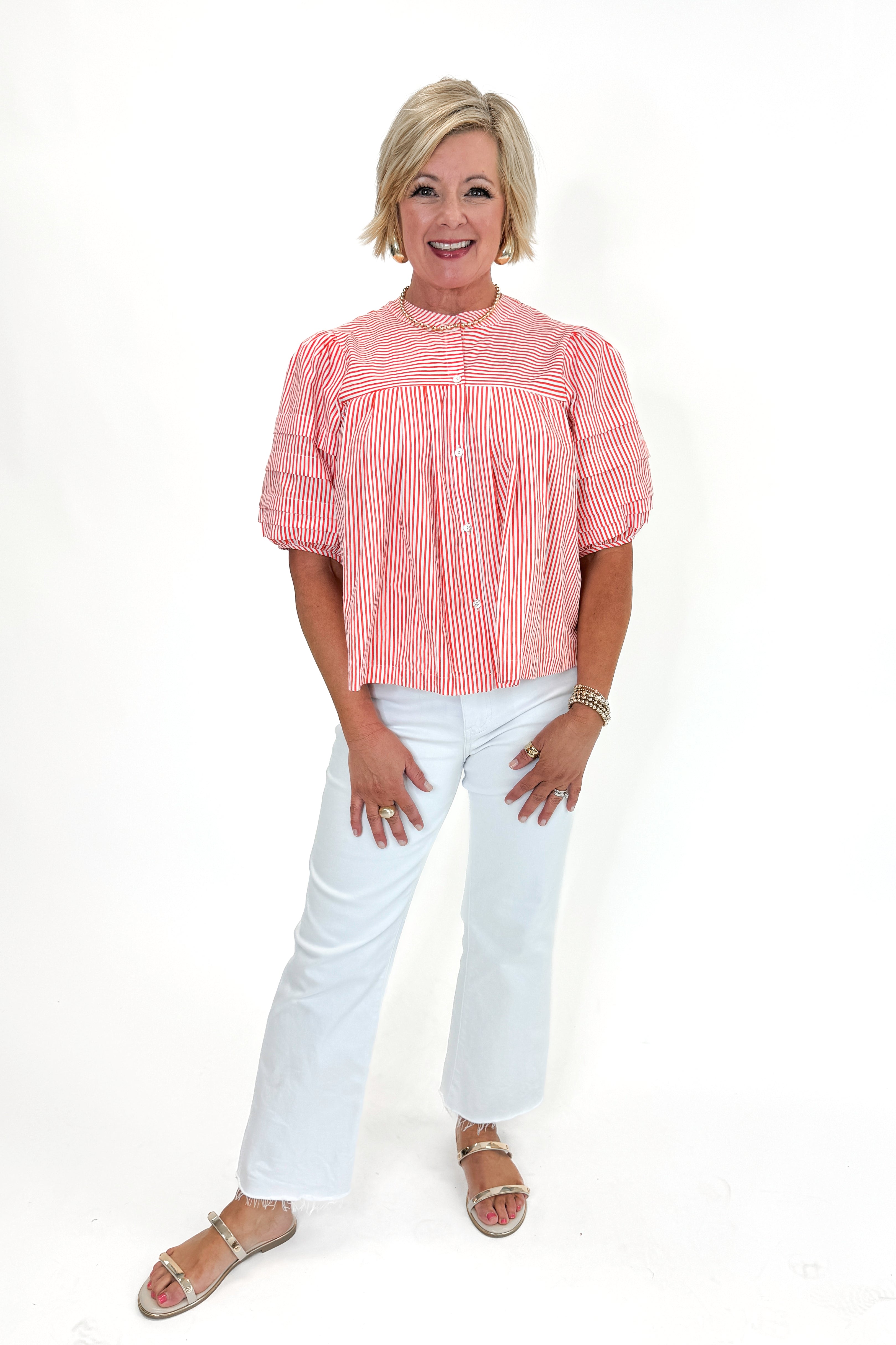 Front view of woman wearing Orange Striped Puff Sleeve Top by Entro with jeans against white studio background.