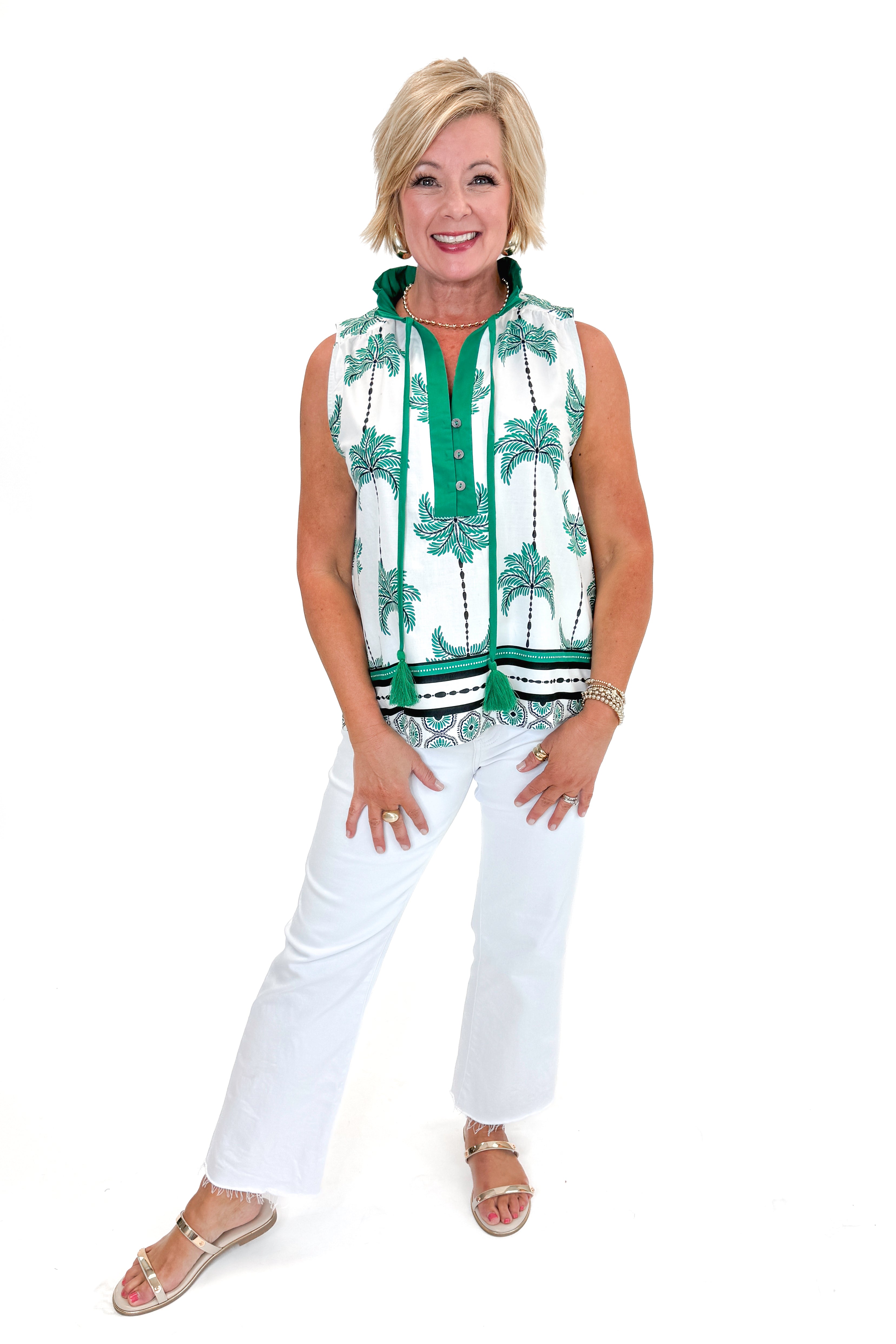 Front view of woman wearing Green Palm Printed Sleeveless Top by Entro with jeans against white studio background.