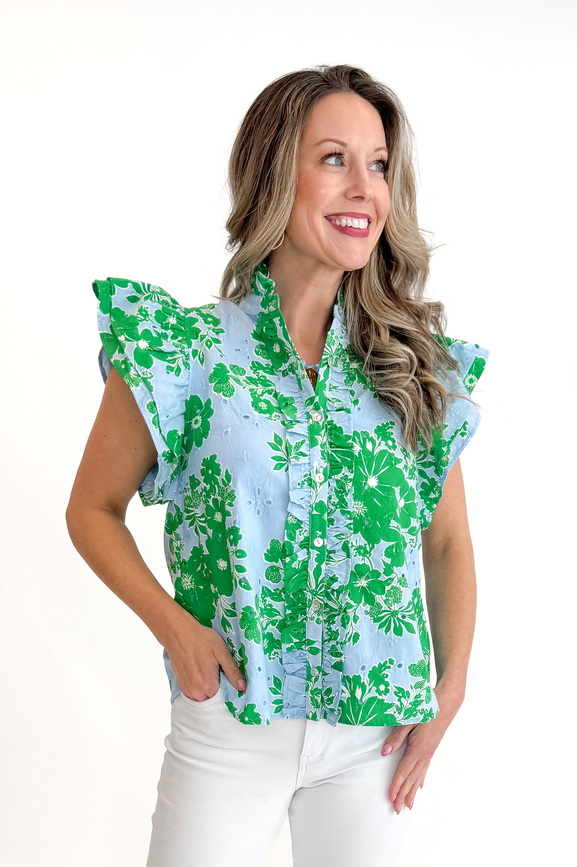 Front view of woman wearing Green & Blue Floral Eyelet Top by Entro with white jeans against white studio background.