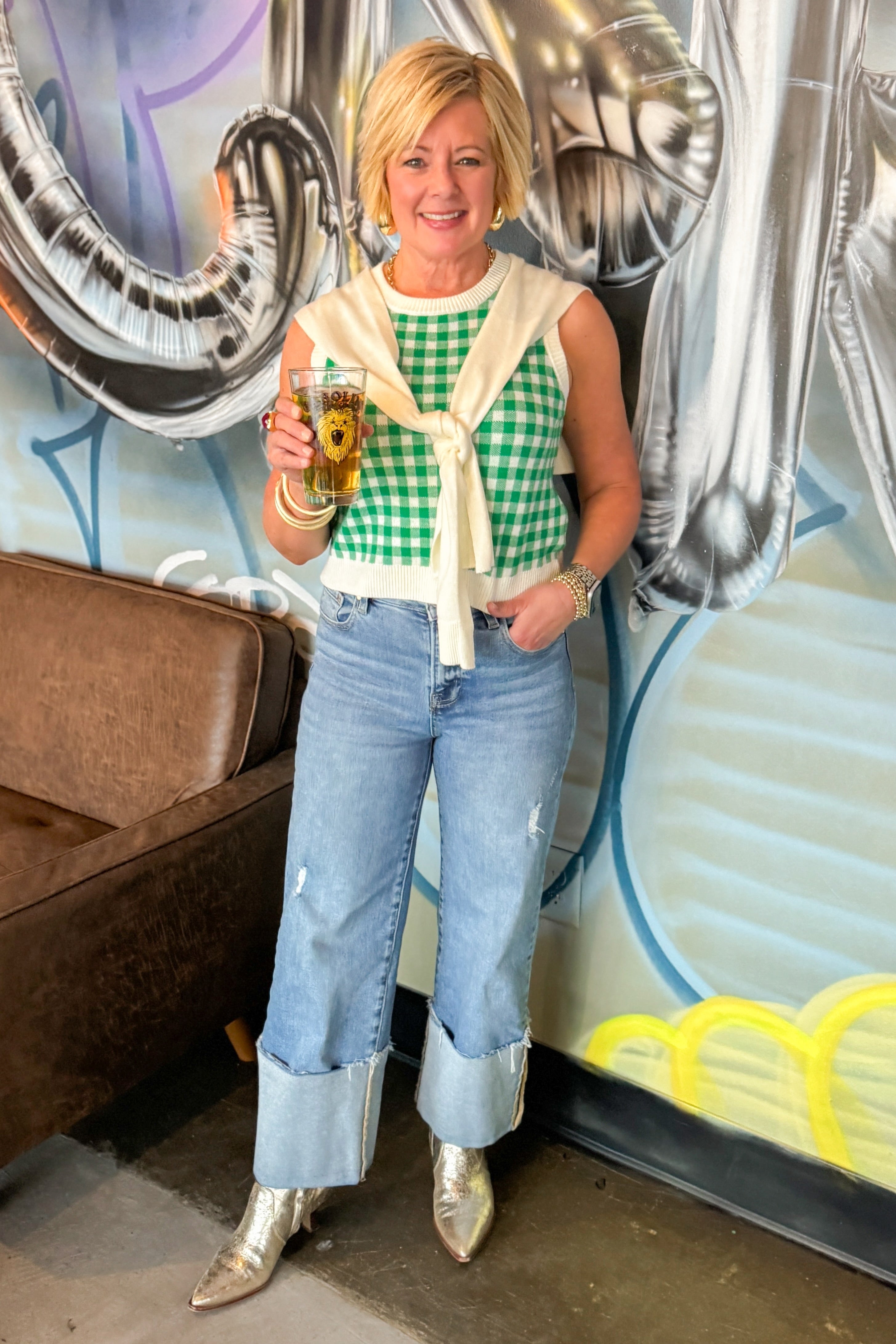 Front view of woman wearing Green Plaid Faux Layered Sweater Tank by Entro with jeans at a bar in Cary.