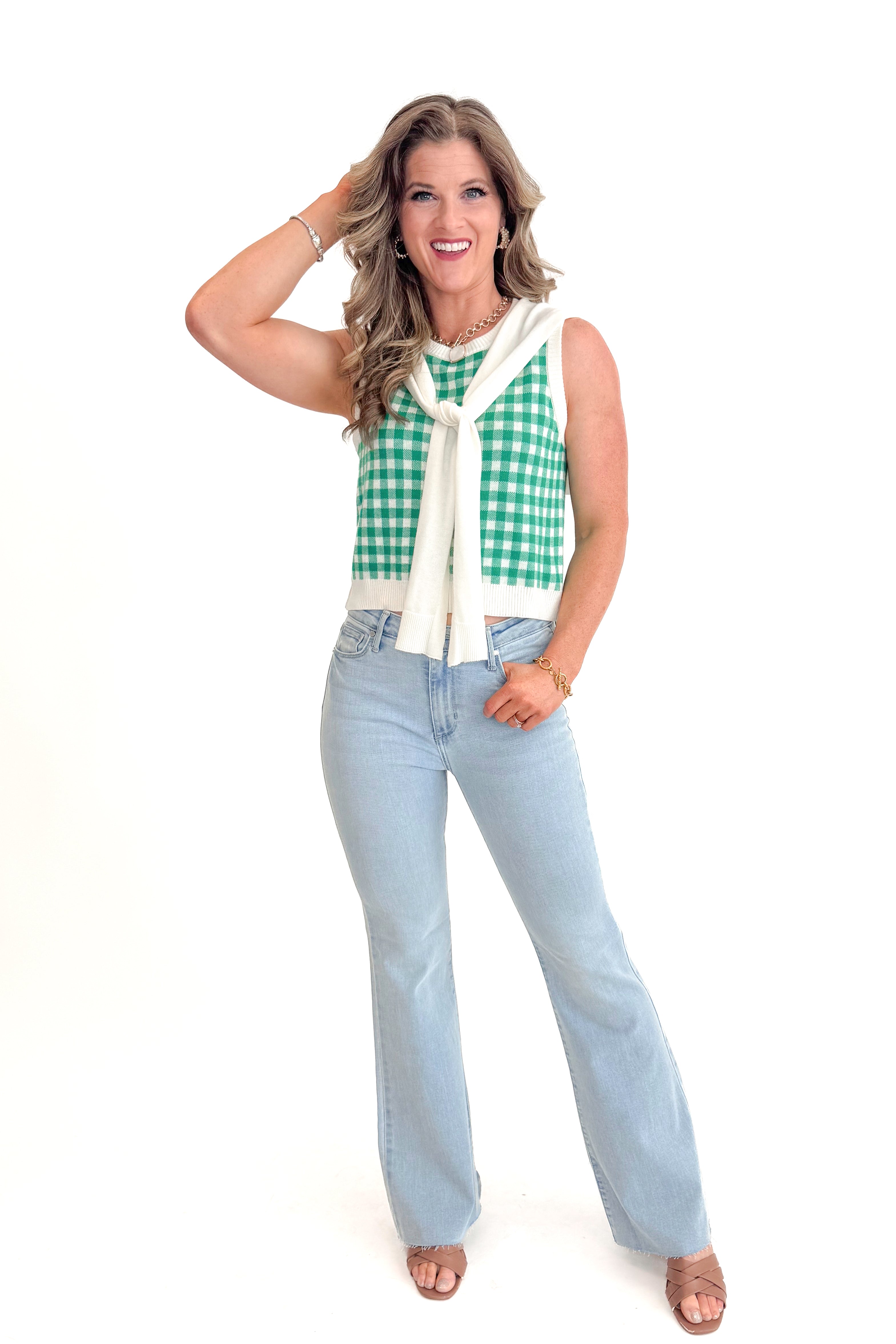 Front view of woman wearing Green Plaid Faux Layered Sweater Tank by Entro with jeans against white studio background.