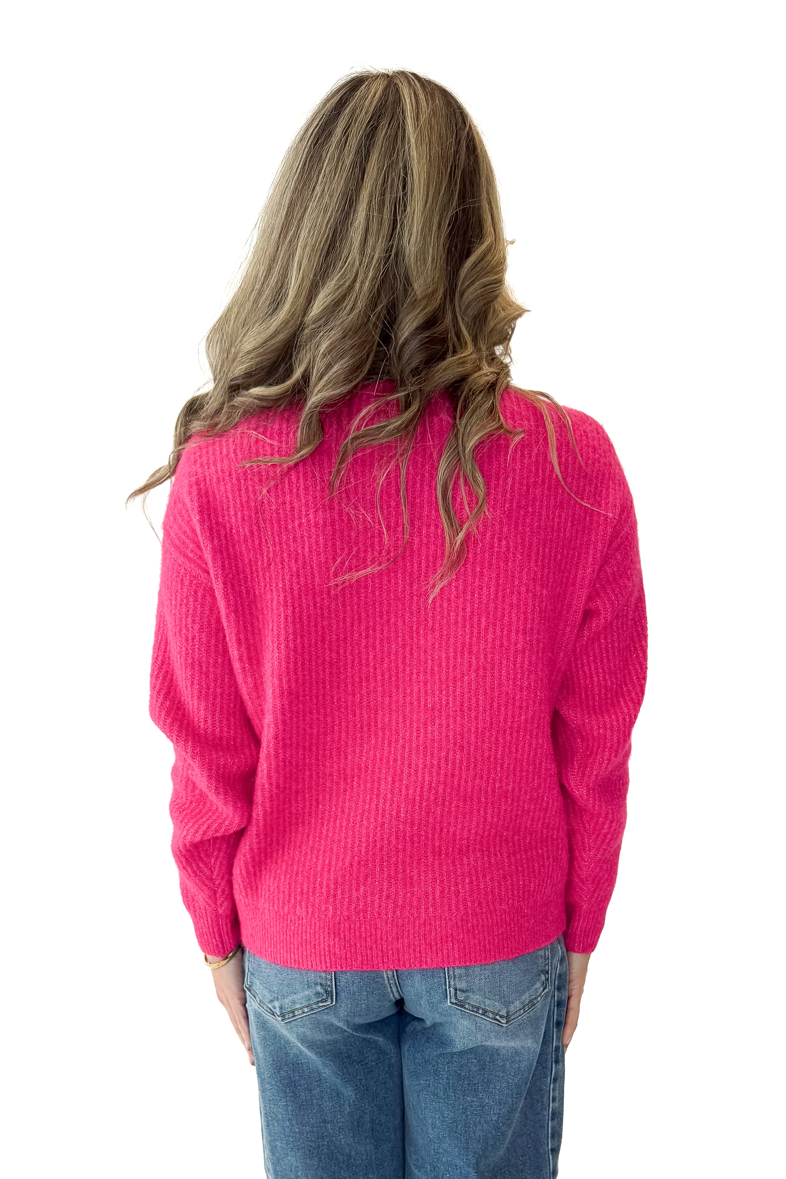 Back view of woman wearing Hot Pink Ribbed Turtleneck Sweater with jeans against white studio background.