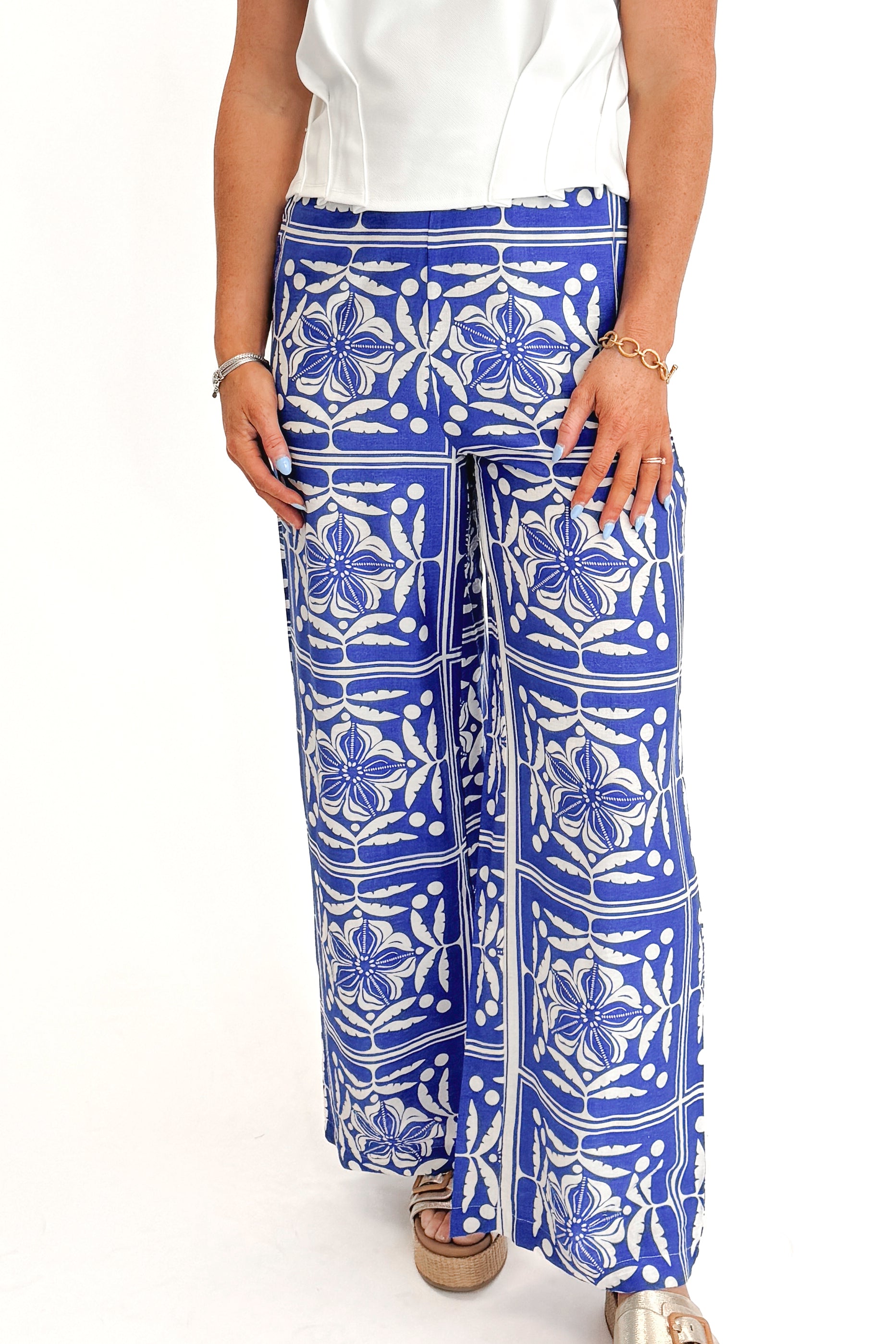Front detail view of woman wearing Blue Floral Print Wide Leg Pants with top against white studio background.