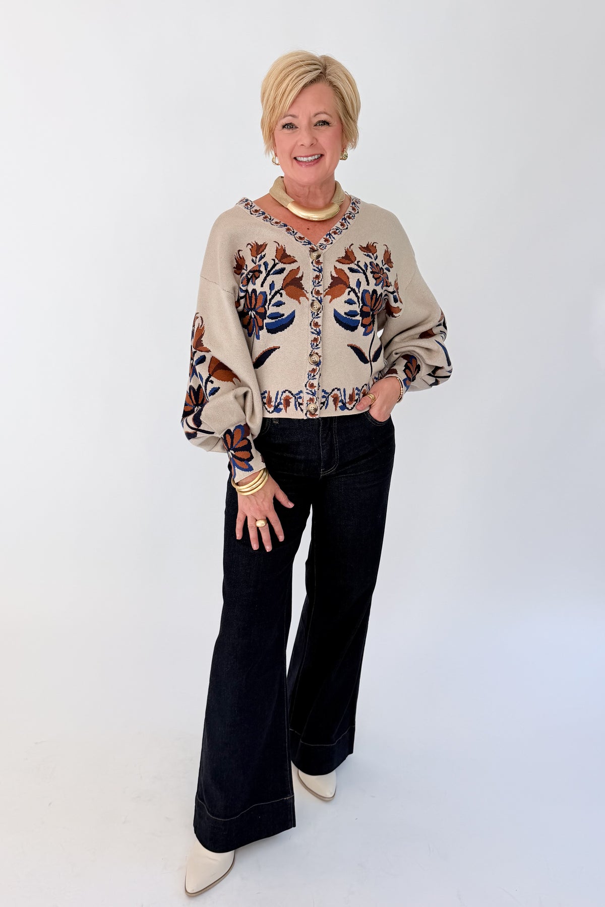 Front view of woman wearing Swagger Boutique’s Taupe Printed V-Neck Cardigan with jeans against white studio background.