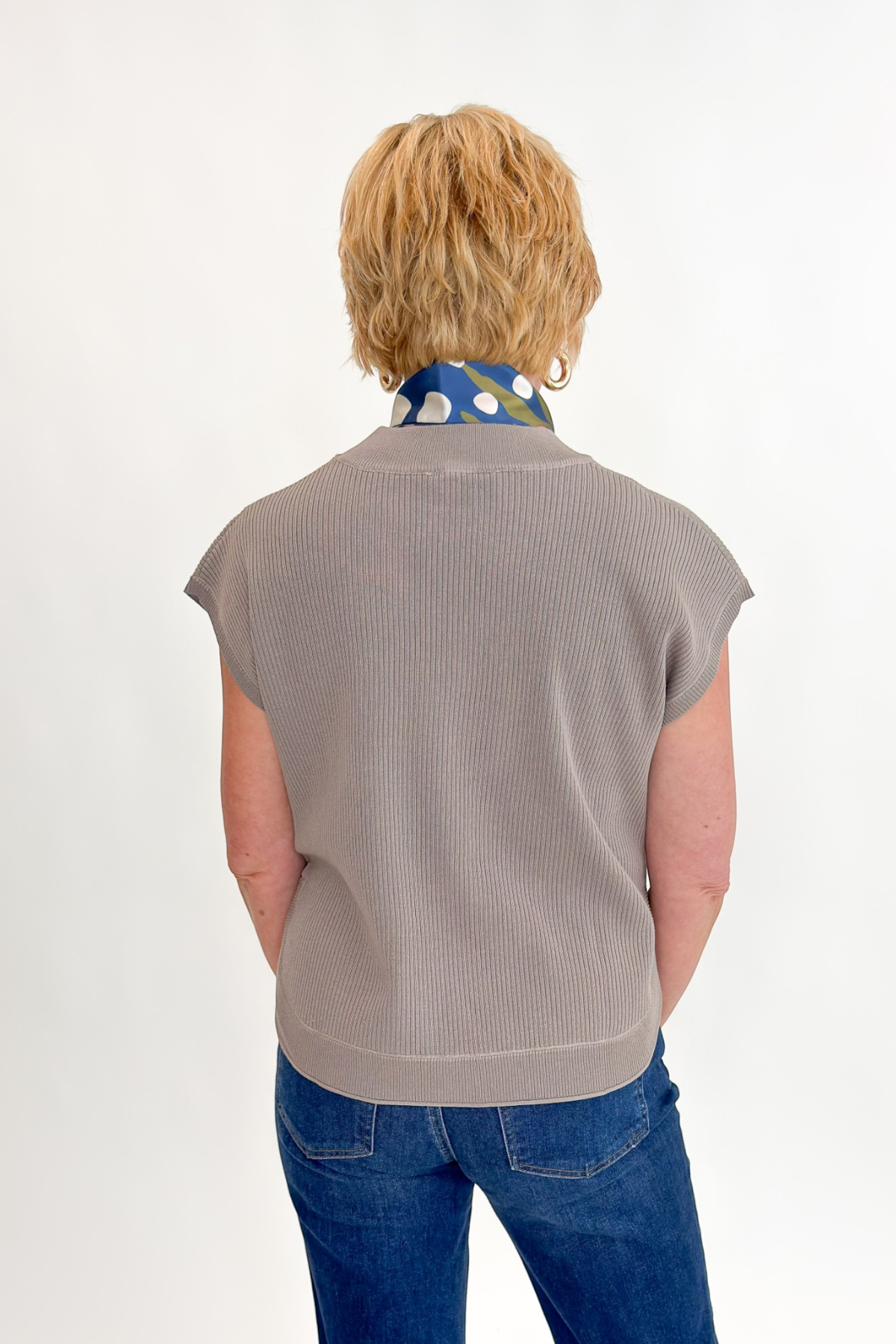 Back view of woman wearing Swagger Boutique’s Taupe Ribbed Short Sleeve Sweater by Entro with jeans against white studio background.