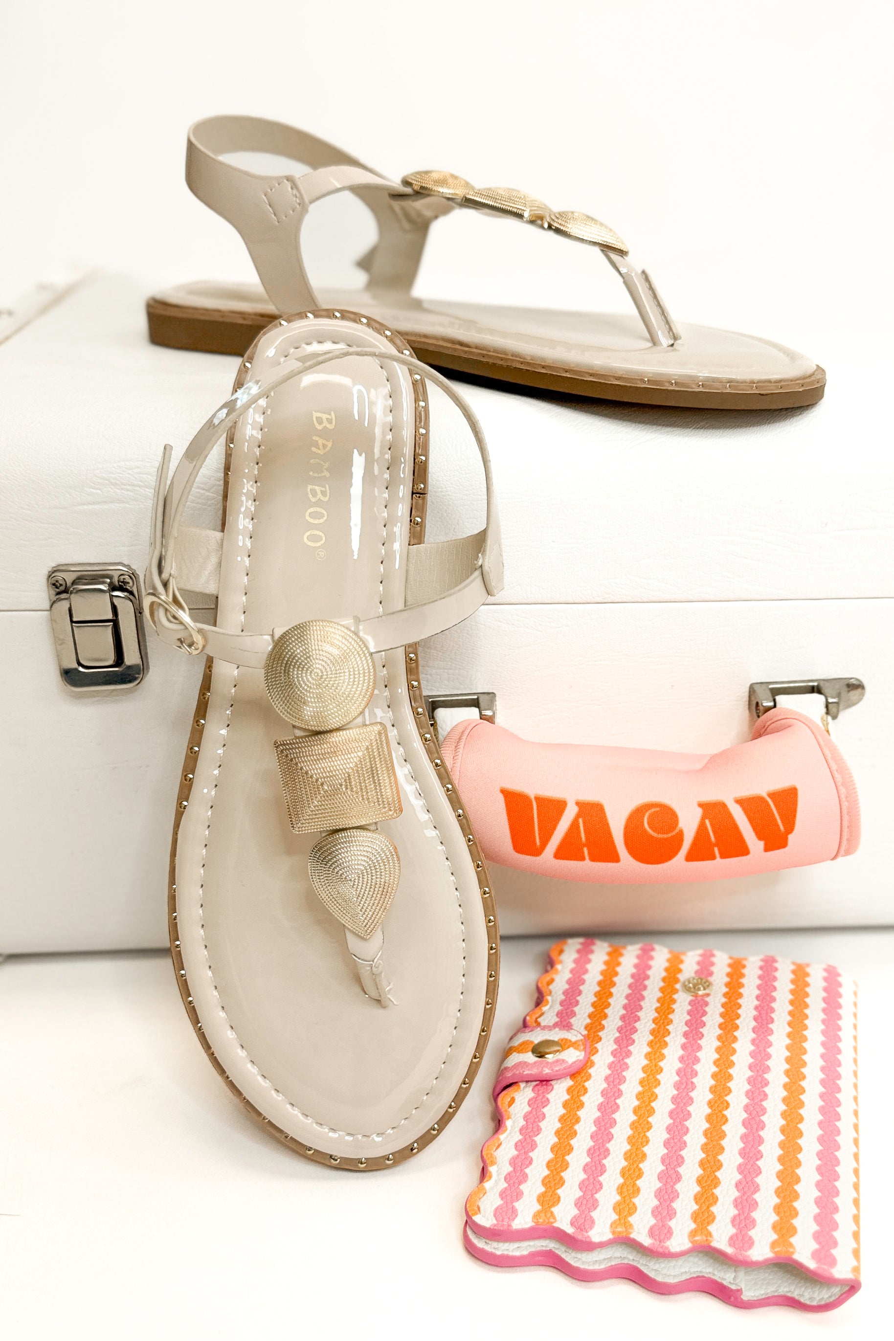 Twinkle- Bone With Gold Charms Sandal with travel accessories against white studio background front and side view.