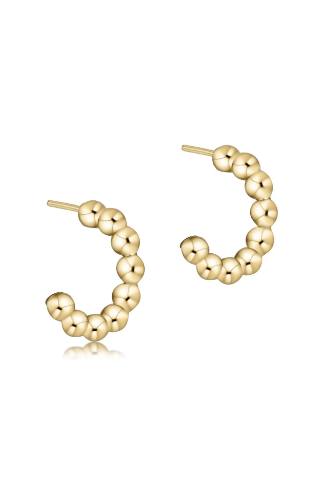 Gold hoop earrings with bead detailing on a white background