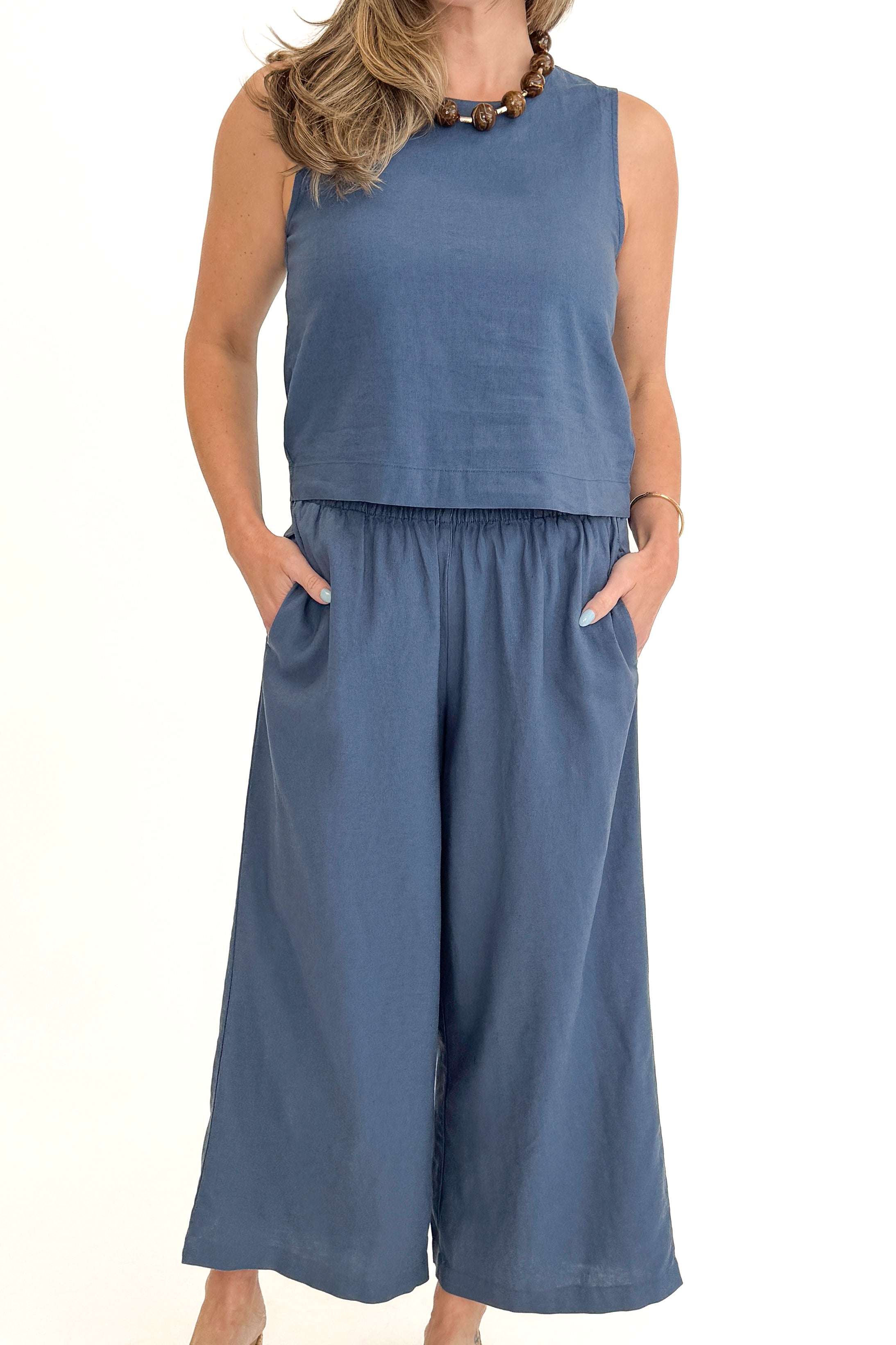 Front view of woman wearing Vintage Indigo Scout Linen Pants by Z Supply with matching Vintage Indigo Sloane Linen Top by Z Supply against white studio background.