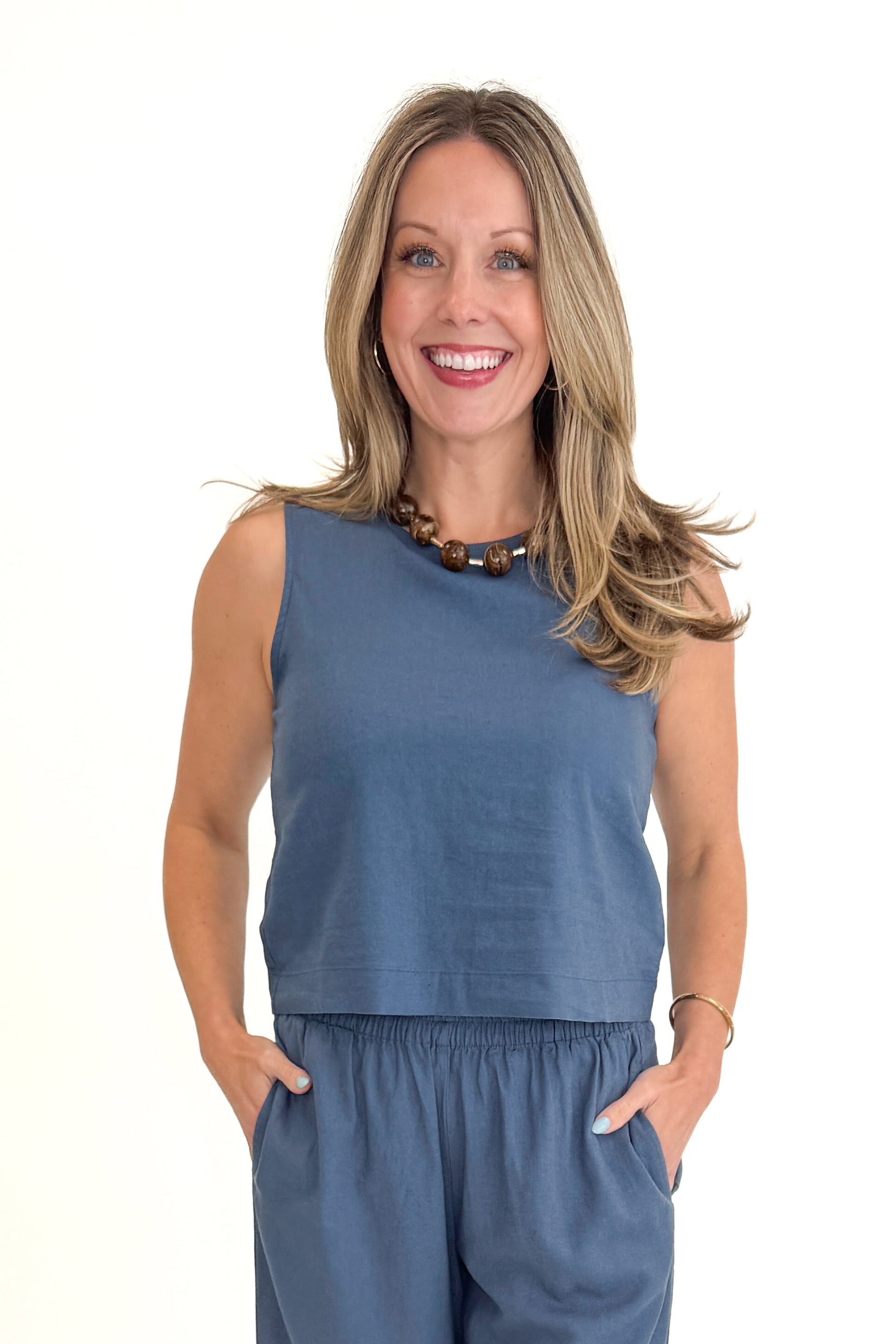 Front view of woman wearing Vintage Indigo Scout Linen Pants by Z Supply with matching Vintage Indigo Sloane Linen Top by Z Supply against white studio background.