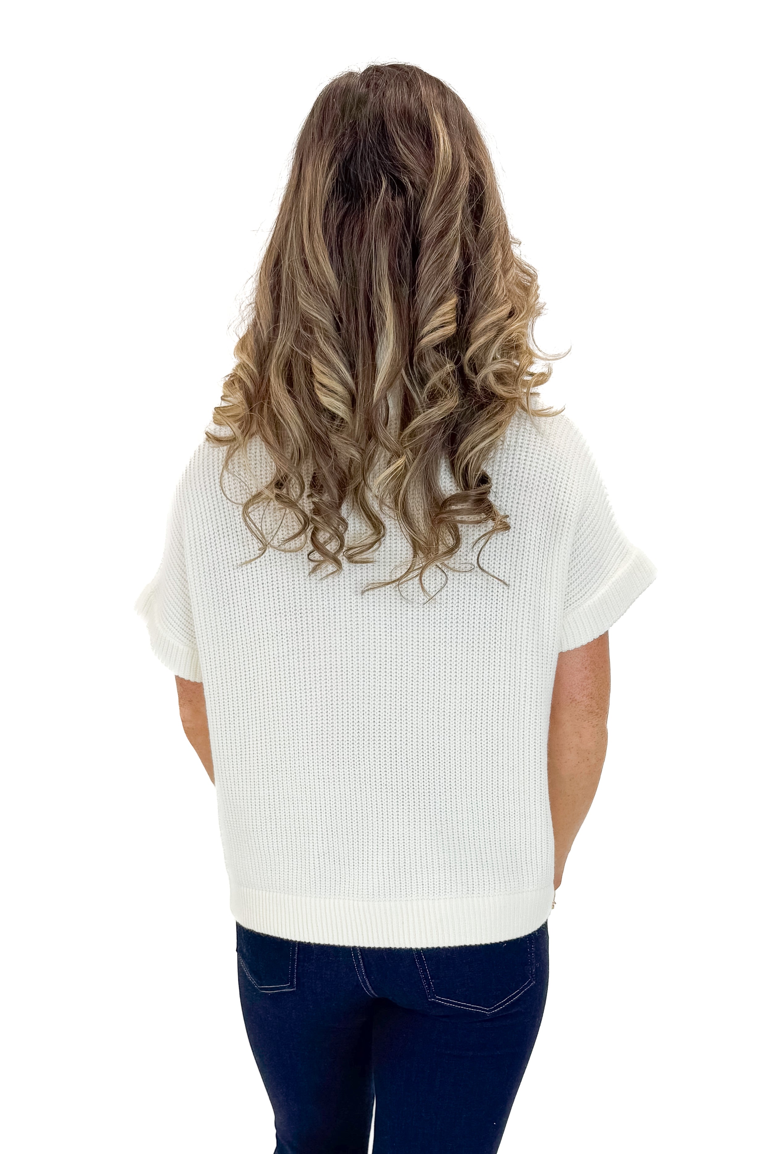 Back view of woman wearing Off White 1/2 Zip Short Sleeve Sweater with jeans against white studio background.