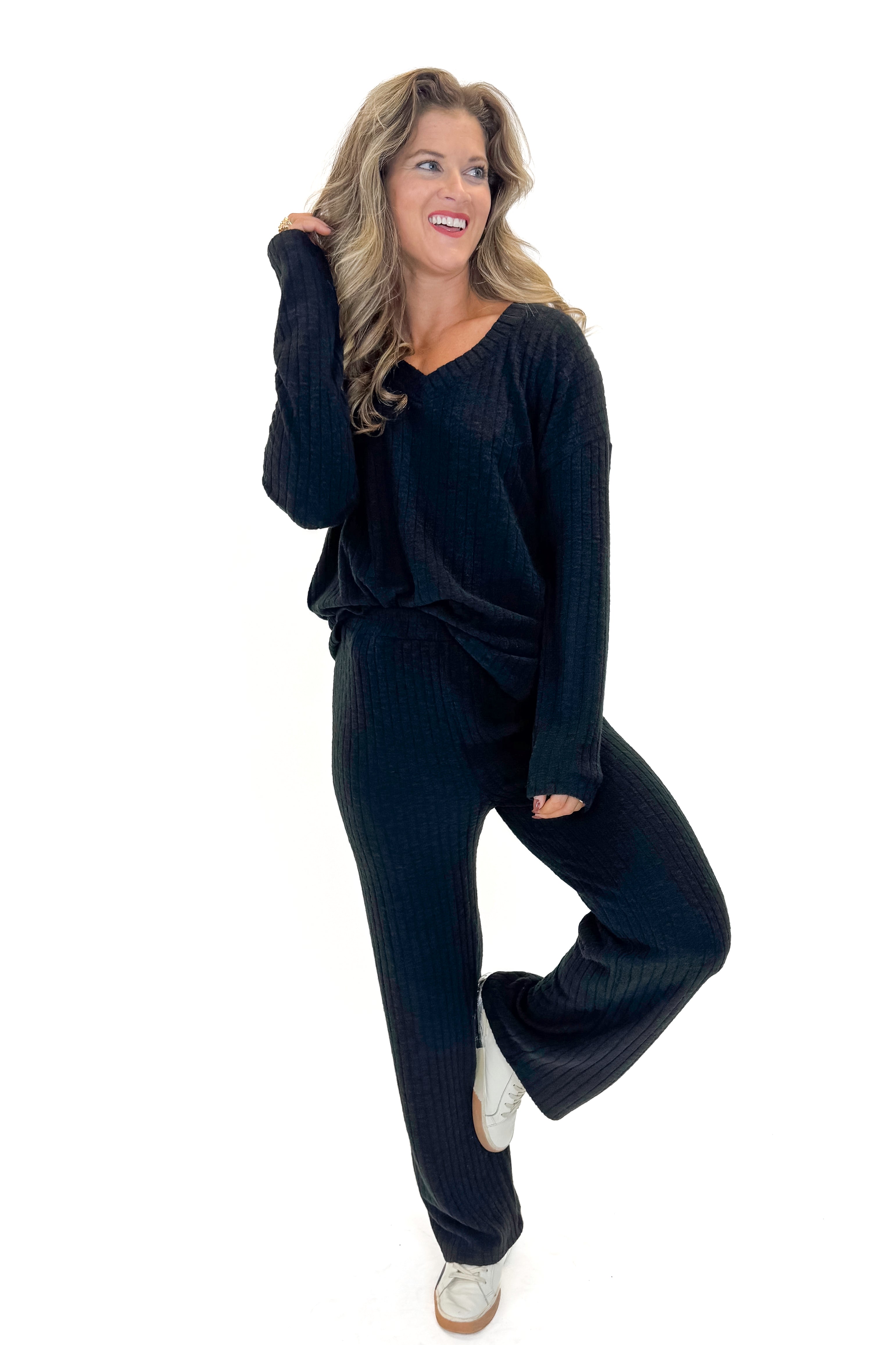 Front view of woman wearing Black Ribbed Lounge Pants with matching top against white studio background.