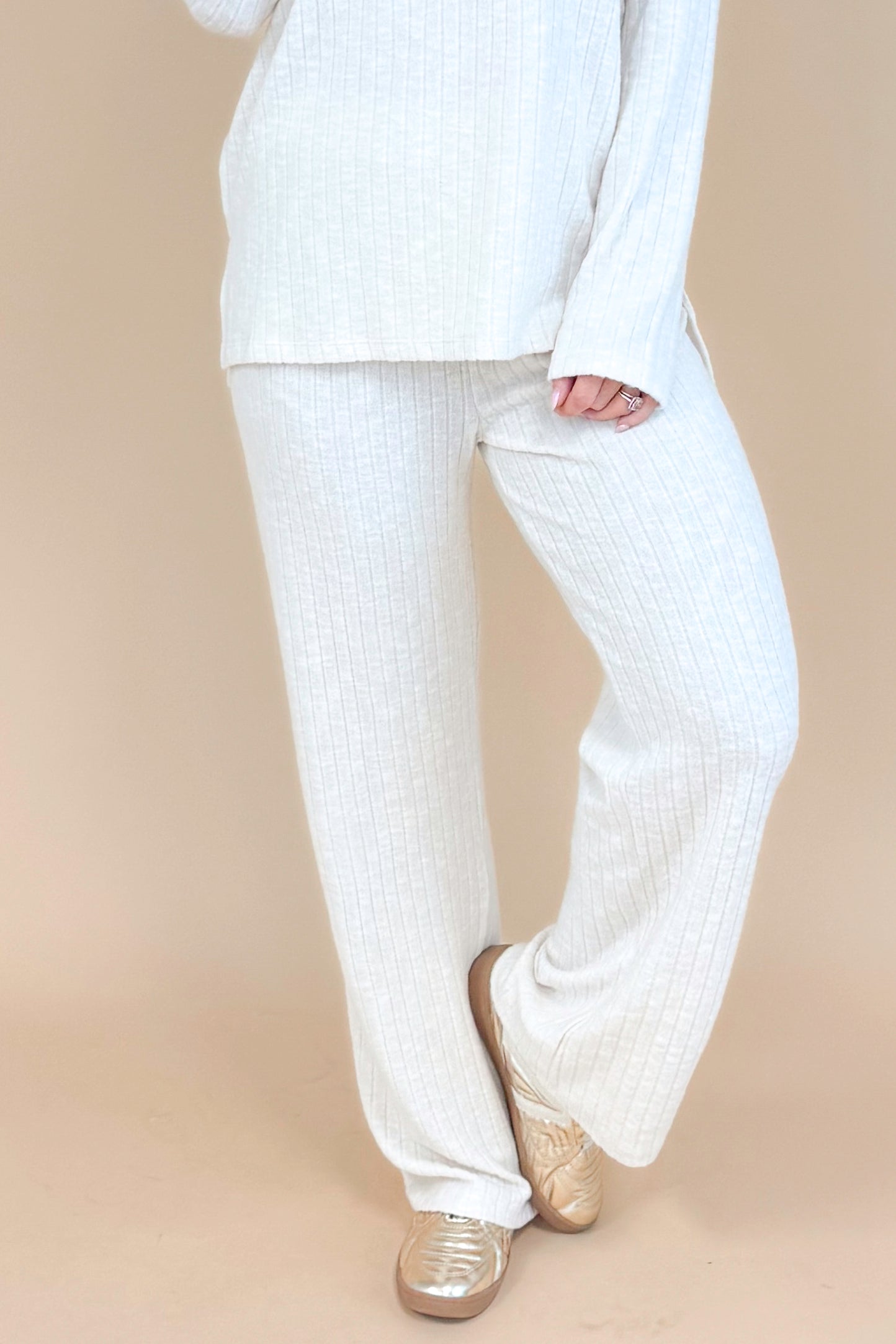 Model wearing cream ribbed lounge pants and matching long sleeve top.
