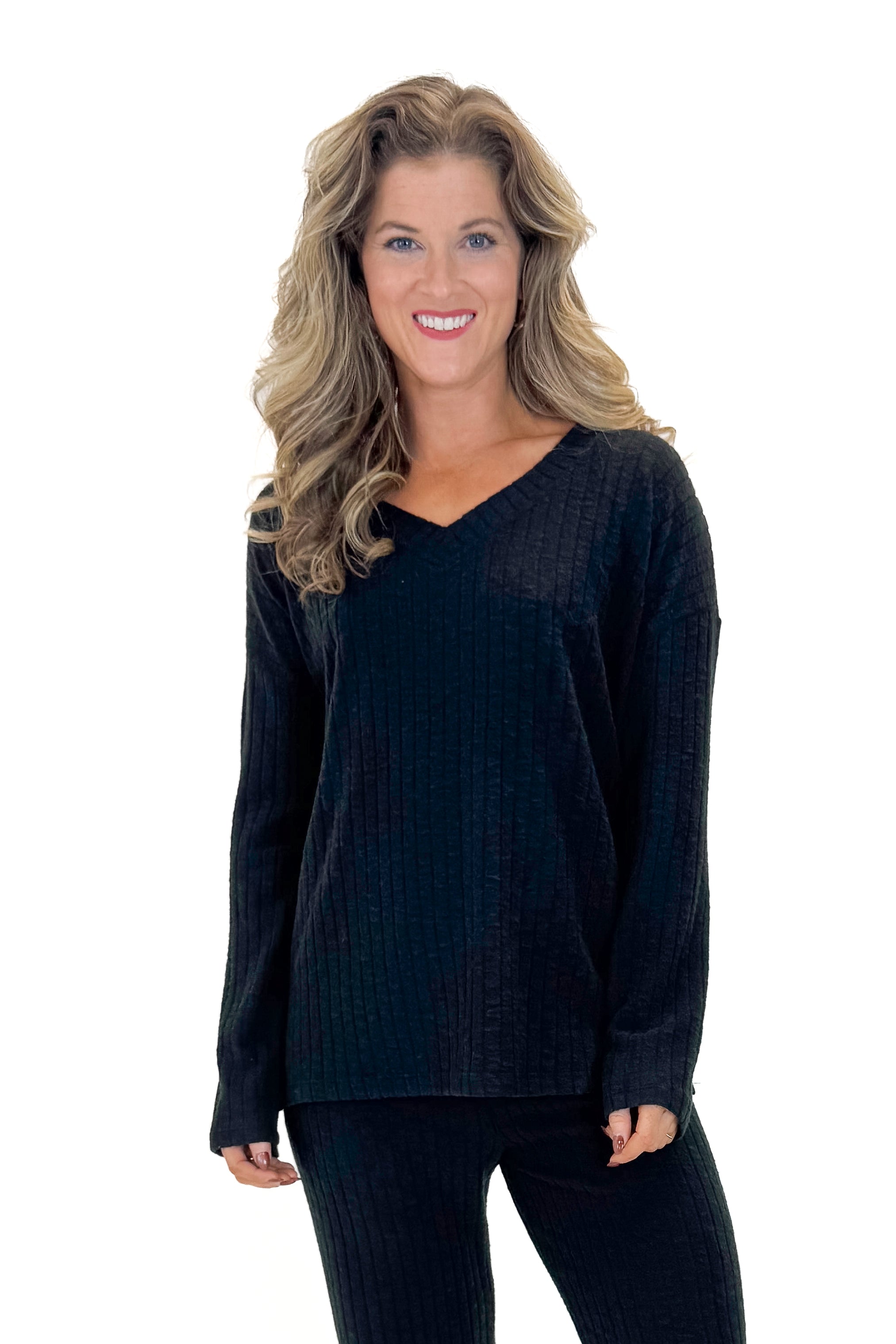 Front view of woman wearing Black Ribbed V-neck Long Sleeve Top with matching pants against white studio background.
