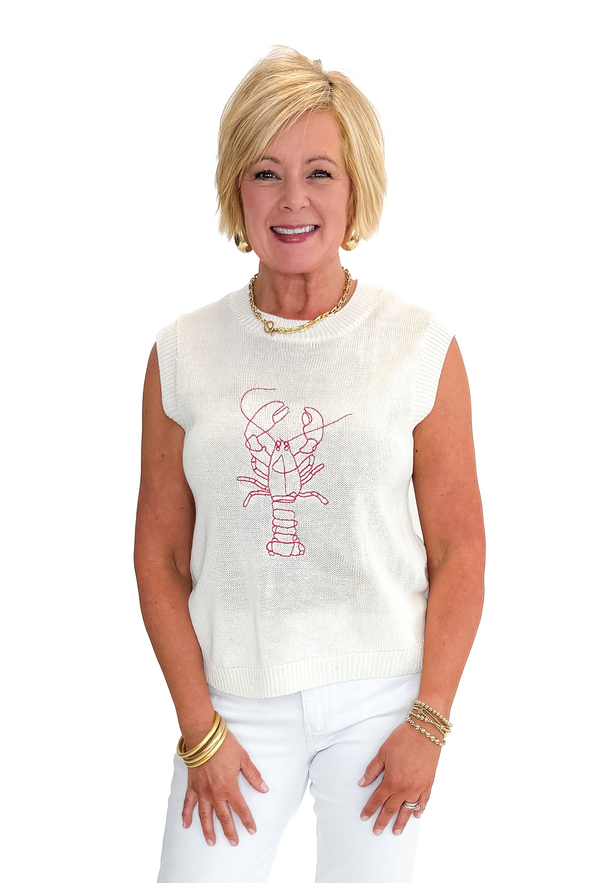 Front view of woman wearing Cream Lobster Embroidered Sleeveless Sweater with jeans against white studio background.