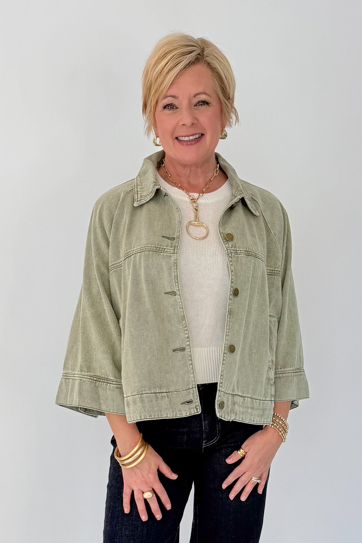 Front view of woman wearing Swagger Boutique’s Washed Olive Utility Jacket with jeans against white studio background.