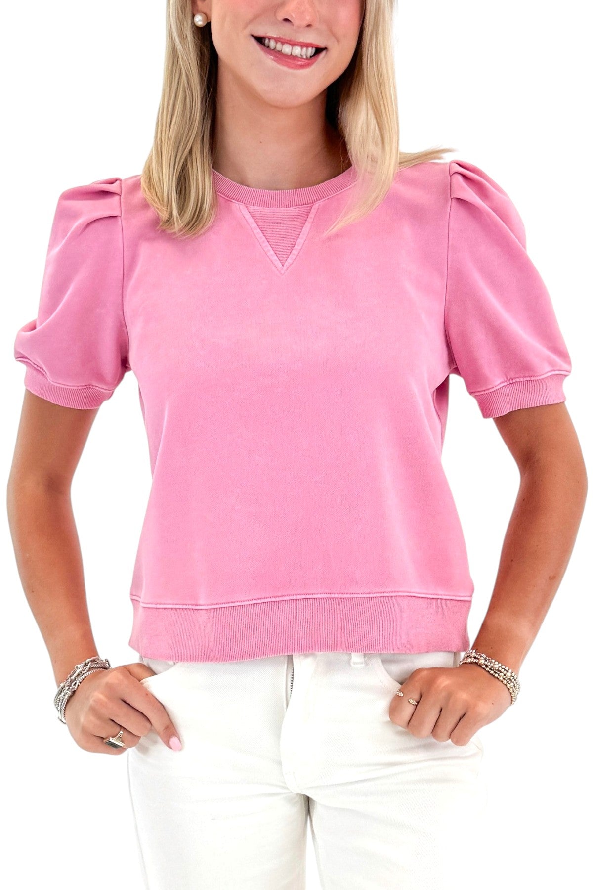 Front detail view of woman wearing Swagger Boutiqueās Washed Pink Short Sleeve Sweatshirt with jeans against white studio background.