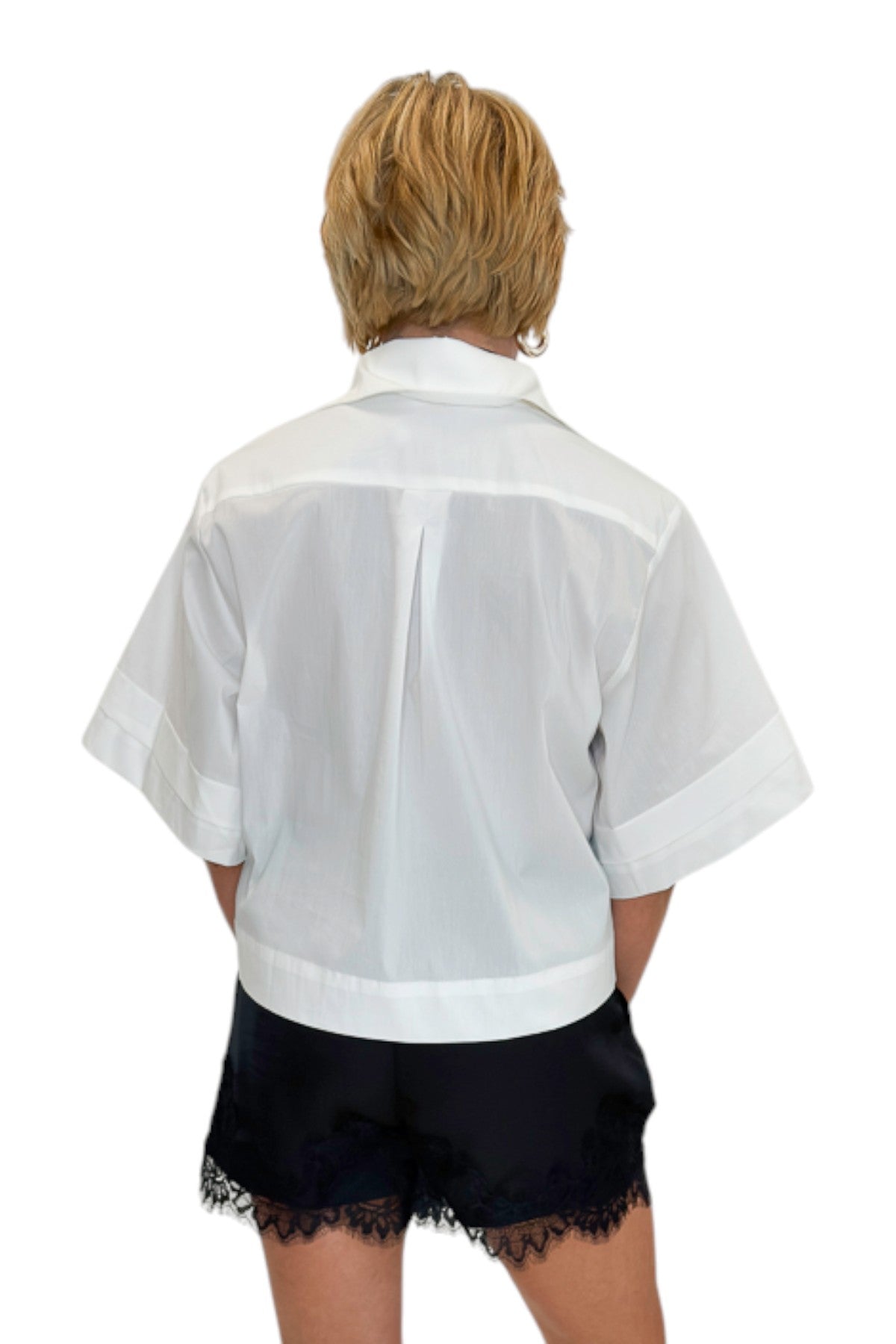 Back view of woman wearing Swagger Boutiqueās White Collared Short Sleeve Top with Black Lace Hem Shorts by Entro against white studio background.