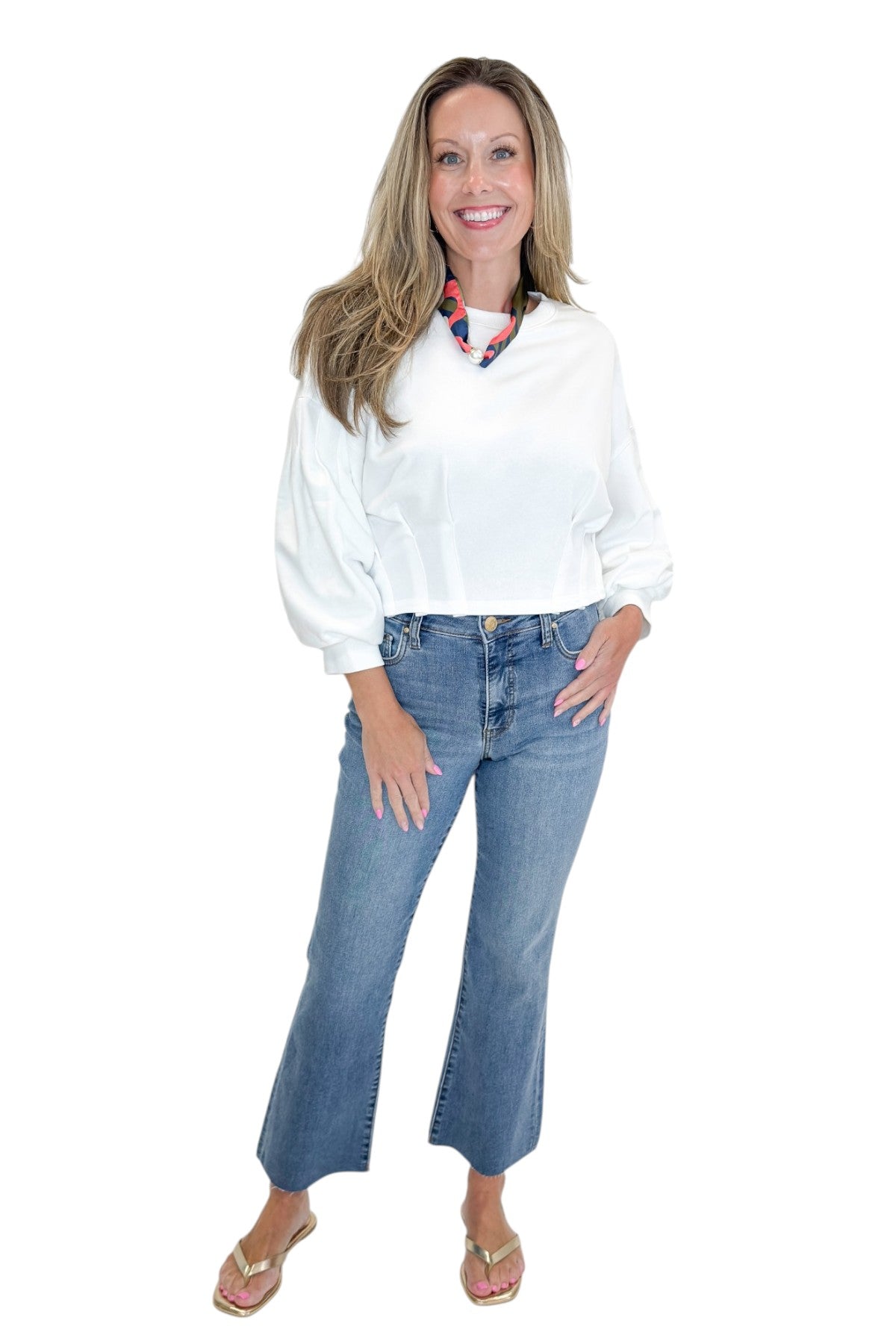 Front view of woman wearing Swagger Boutiqueās White Cropped 3/4 Sleeve Sweatshirt by Entro with jeans against white studio background.