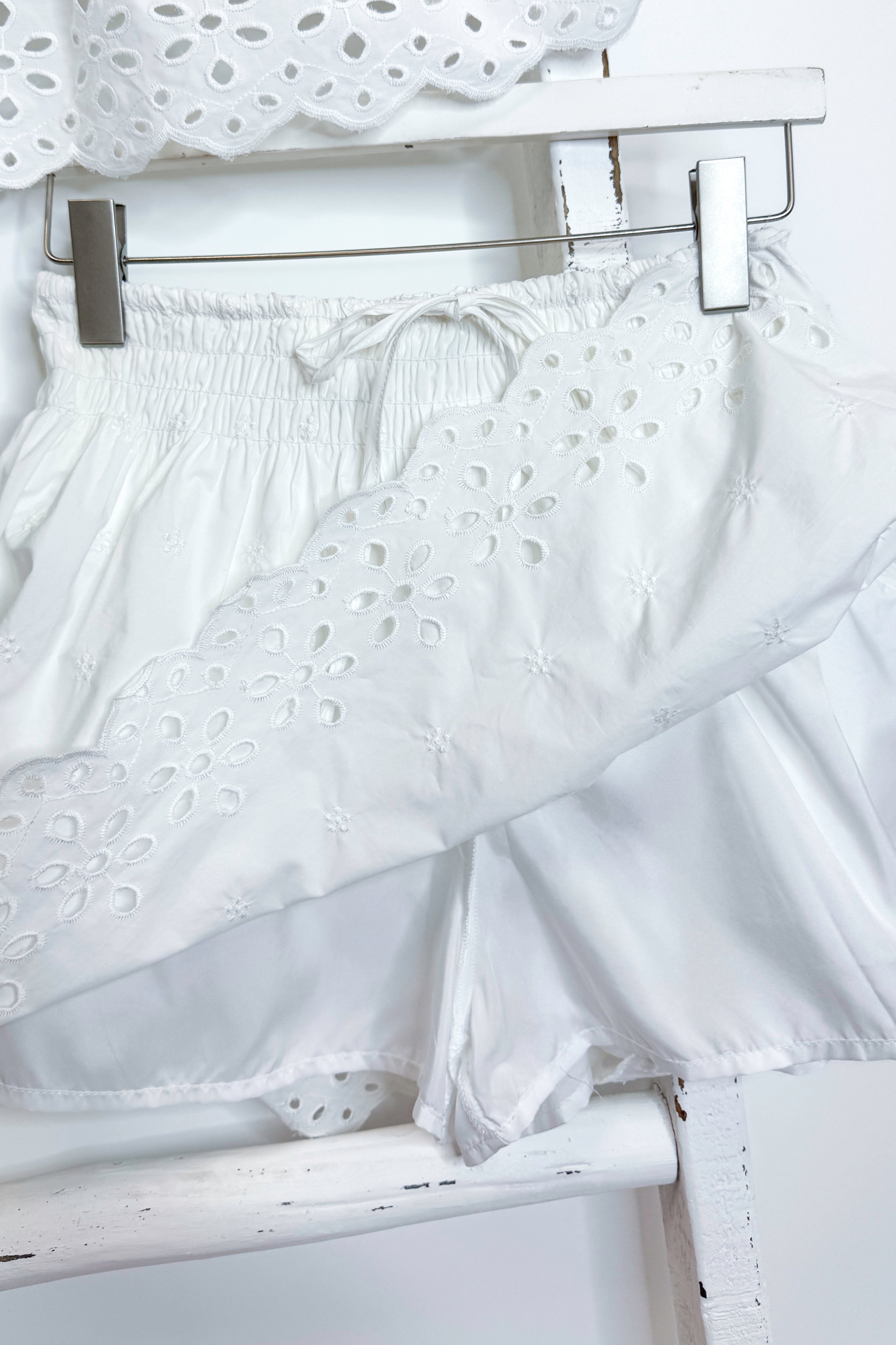 White eyelet skirt with hidden shorts against white background.