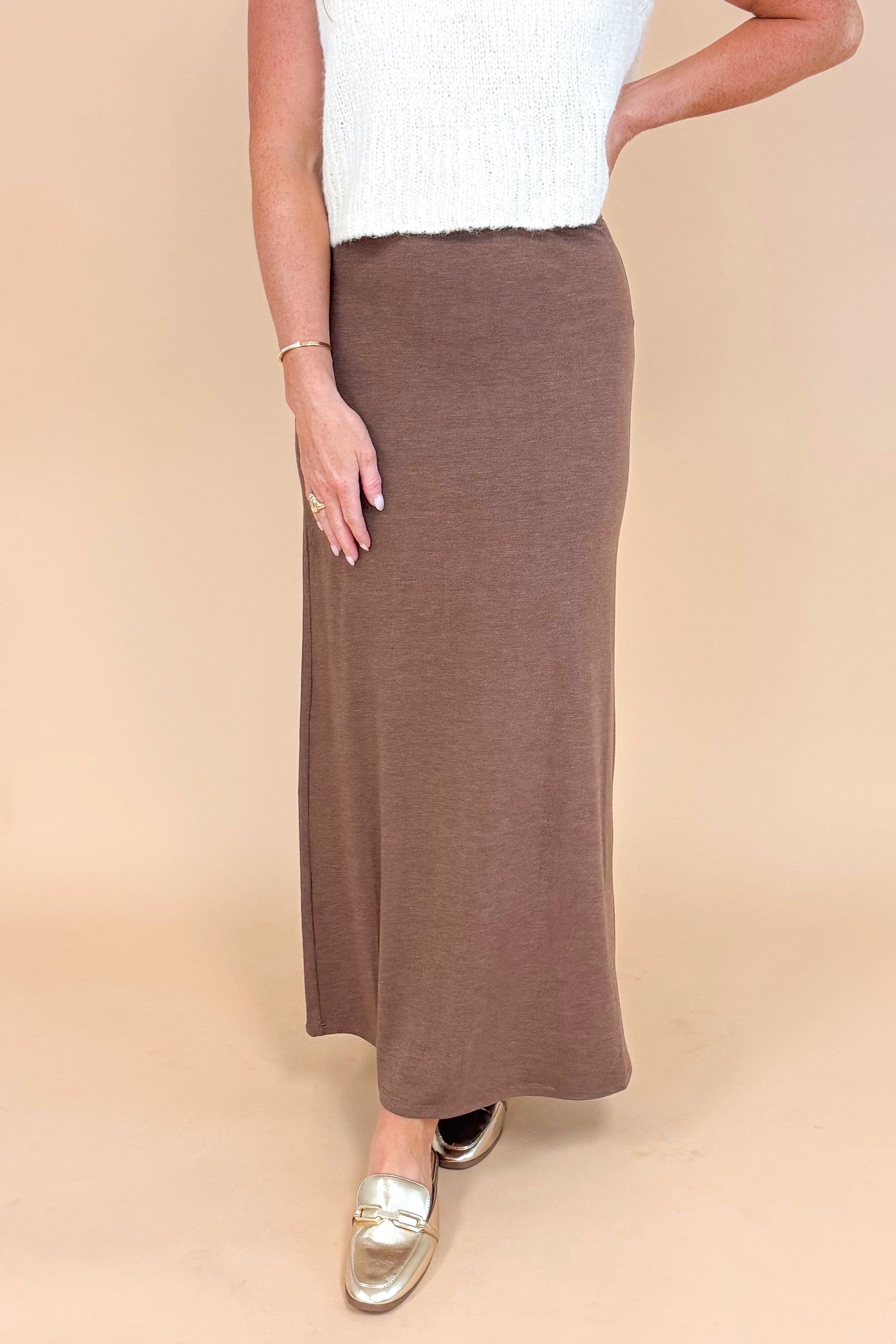 Woman wearing brown Demure Maxi Skirt by Z Supply - detailed front view showing flowy silhouette and elastic waistband