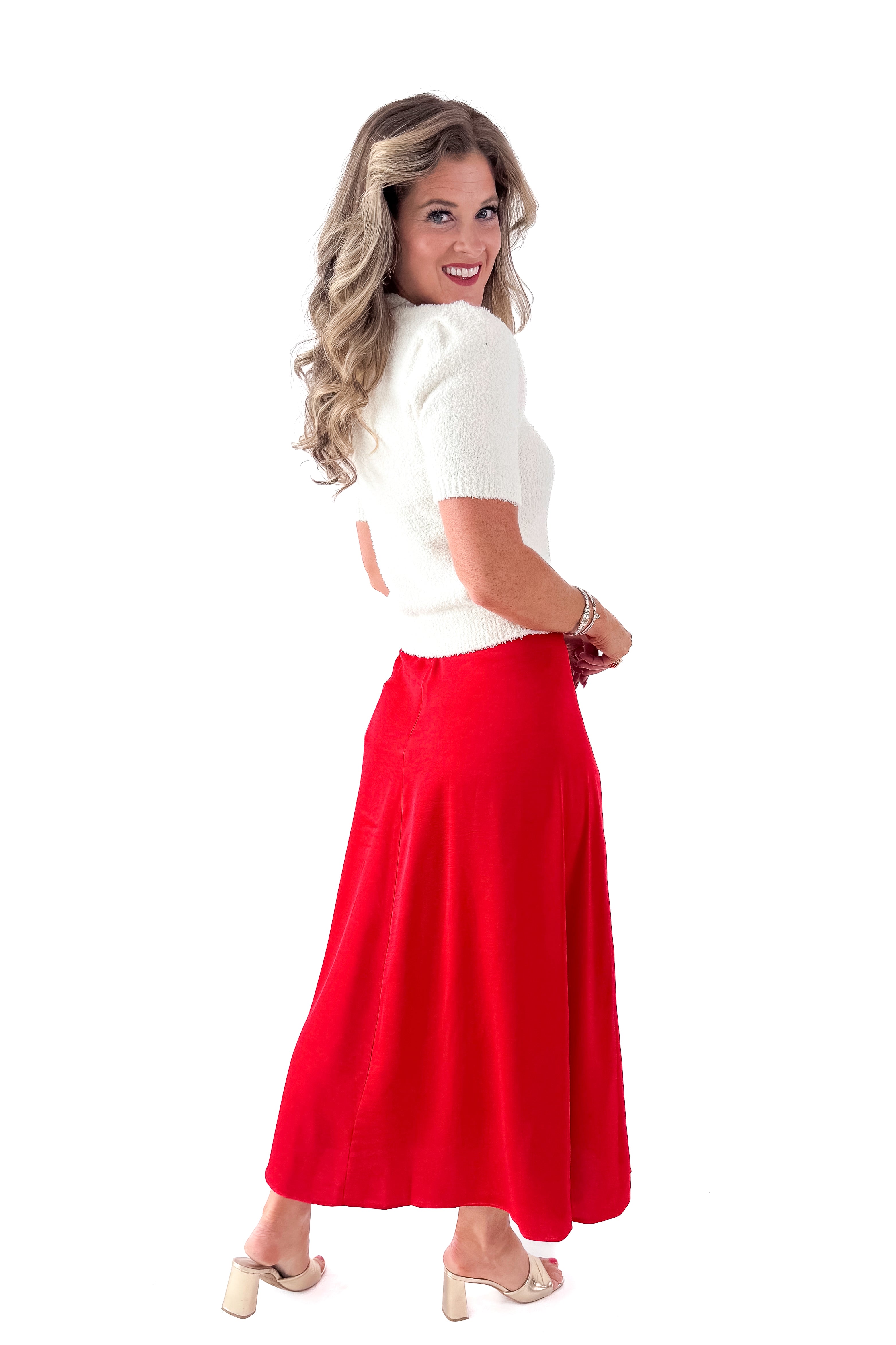 Side view of woman wearing cream top with Festive Red Northpointe Midi Skirt against white studio background.