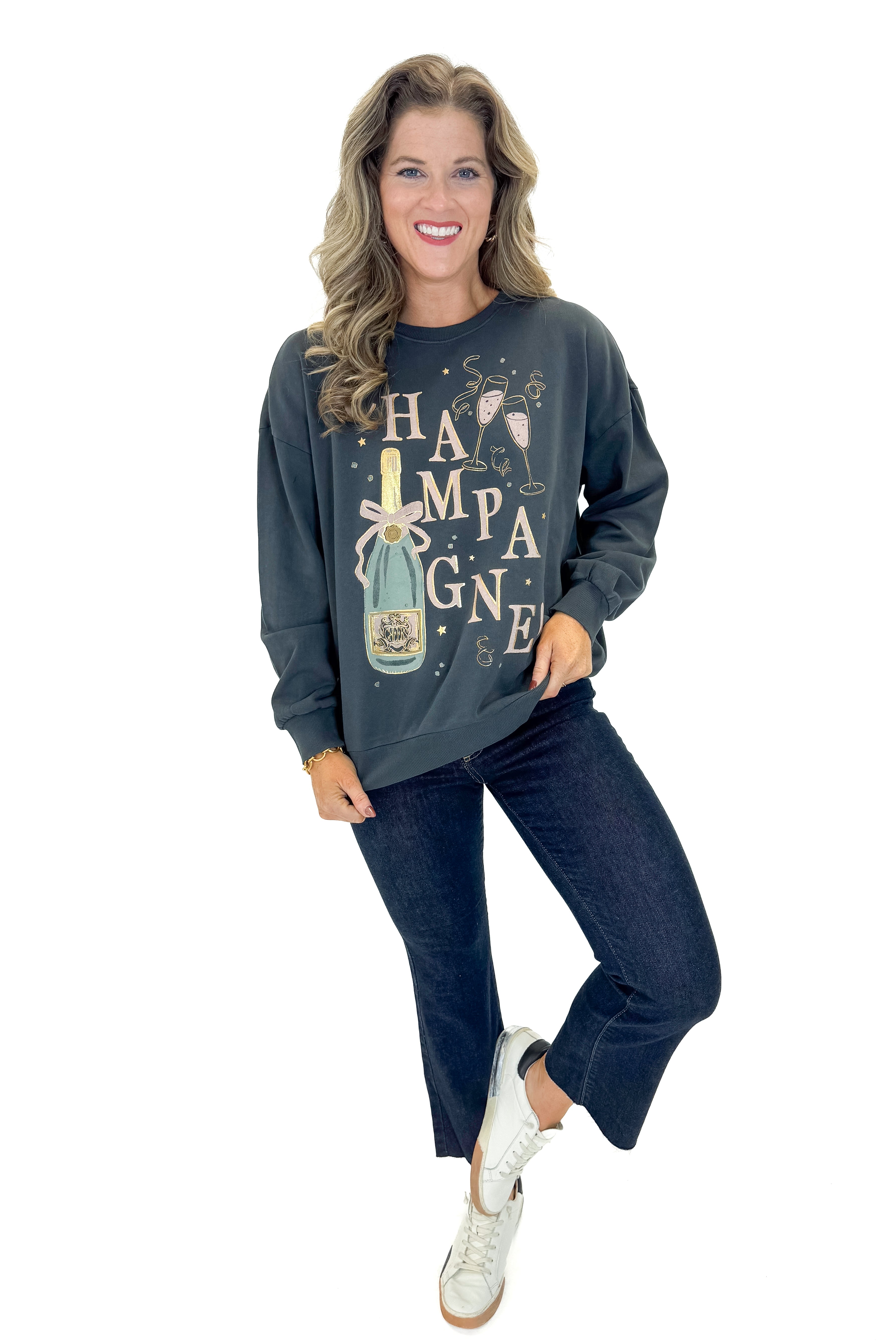 Front view of woman wearing Black Celebrate Sunday Sweatshirt with jeans against white studio background.