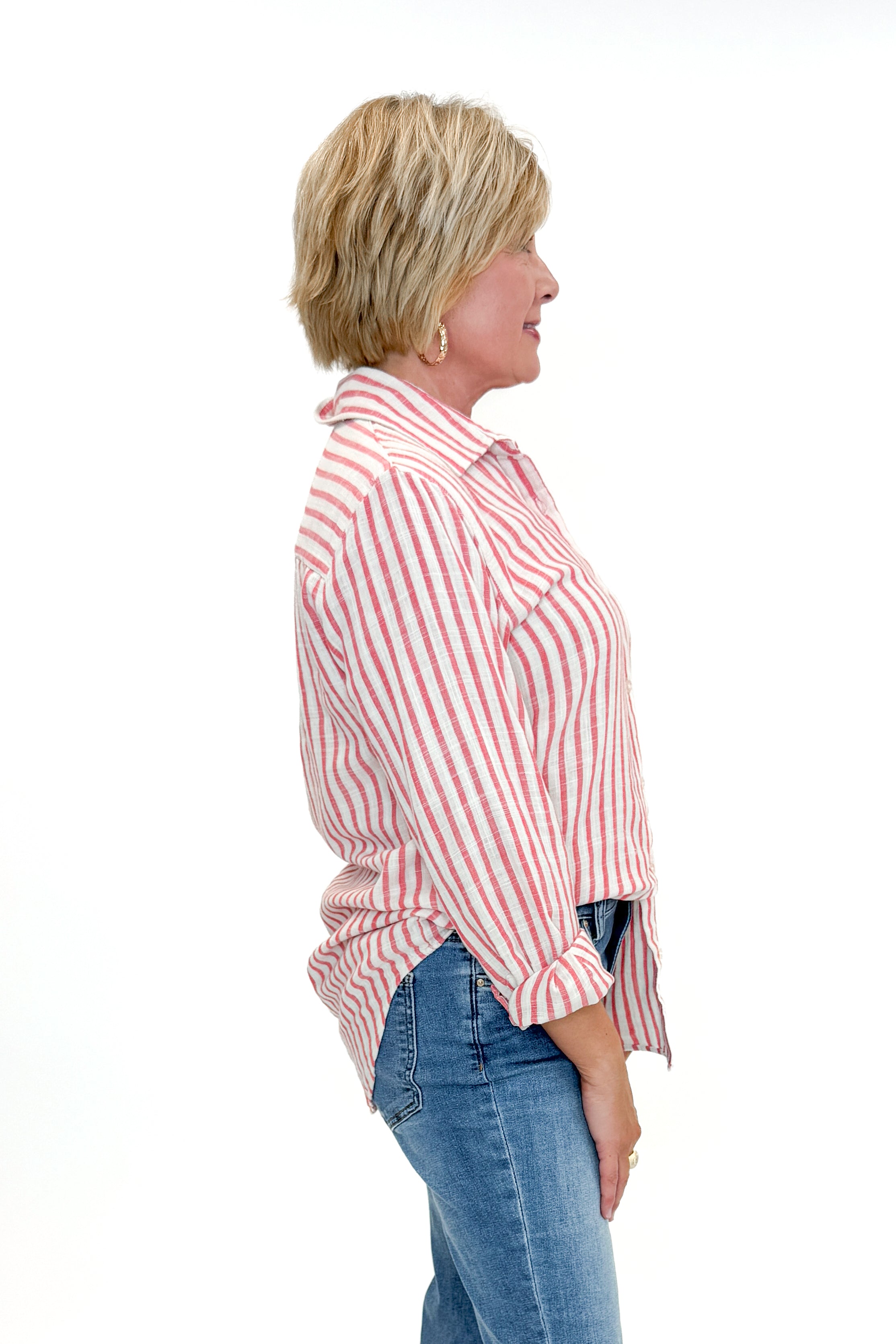 Side view of woman wearing Crimson Crush Saturdays Stripe Shirt by Z Supply with jeans against white studio background.