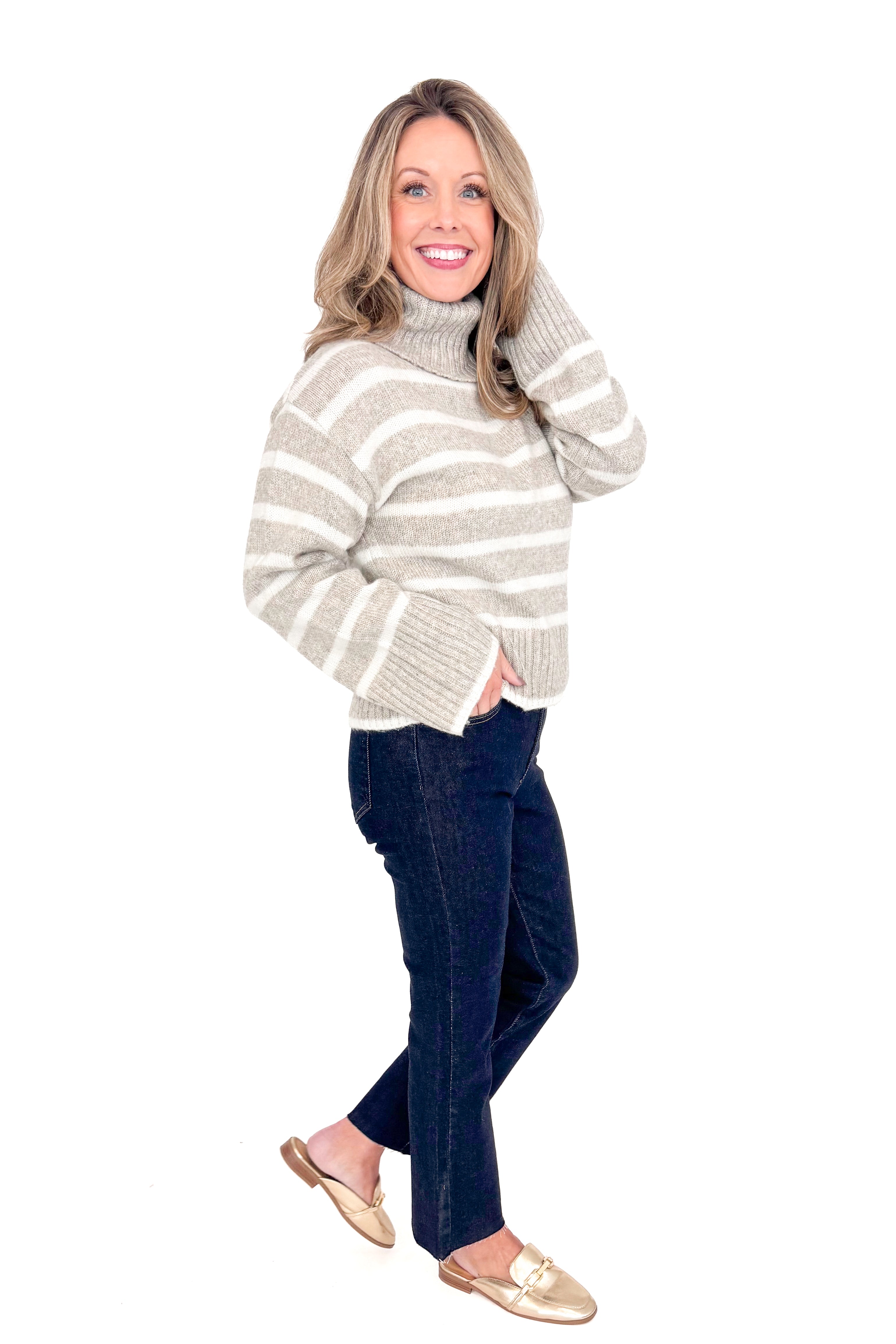 Side view of woman wearing Z Supply stripe Josephine sweater with jeans against white studio background.