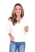 Front view of woman wearing Z Supply cream top with jeans against white studio background.