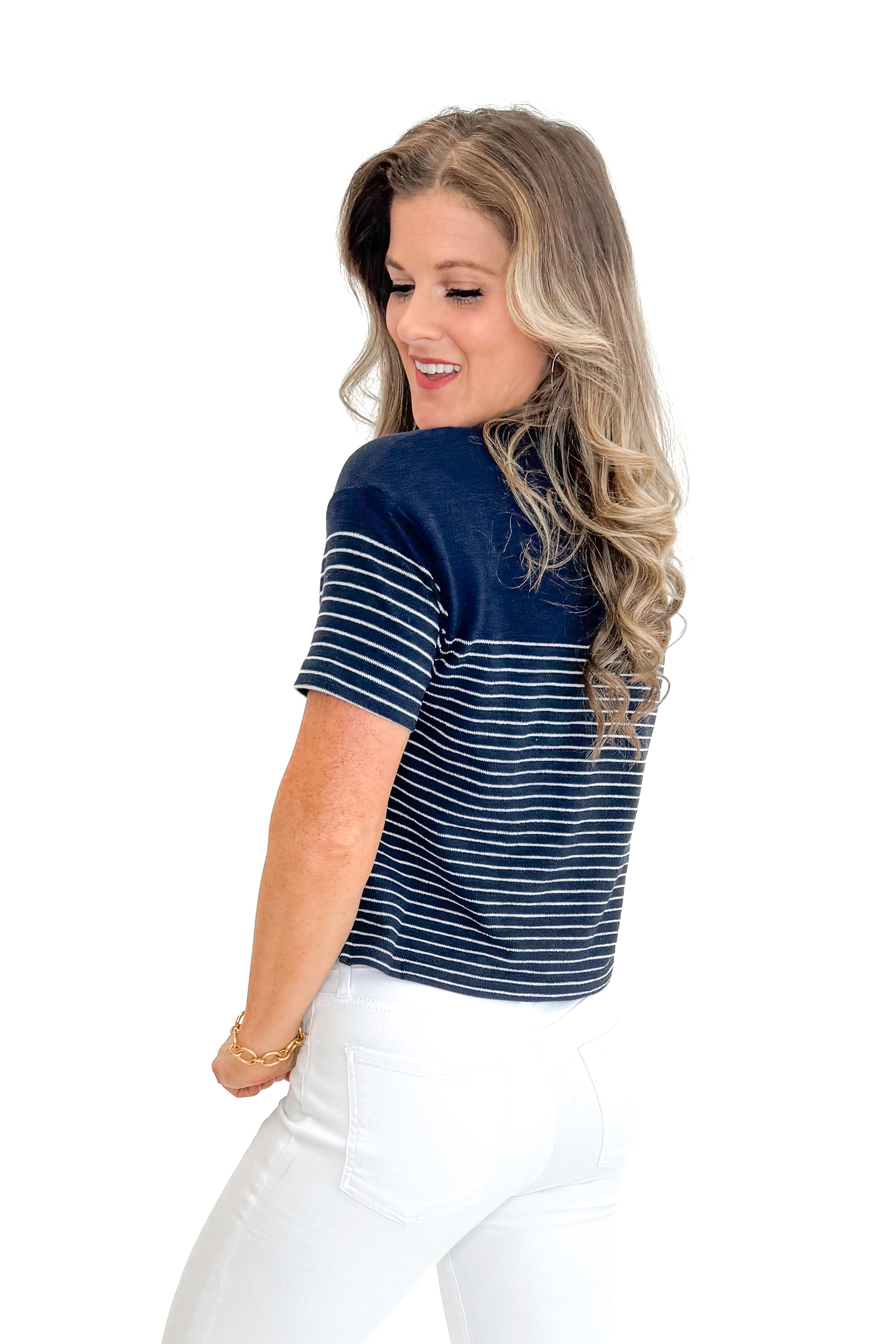 Side view of woman wearing Eclipse Harbor Striped Shirt by Z Supply with jeans against white studio background.