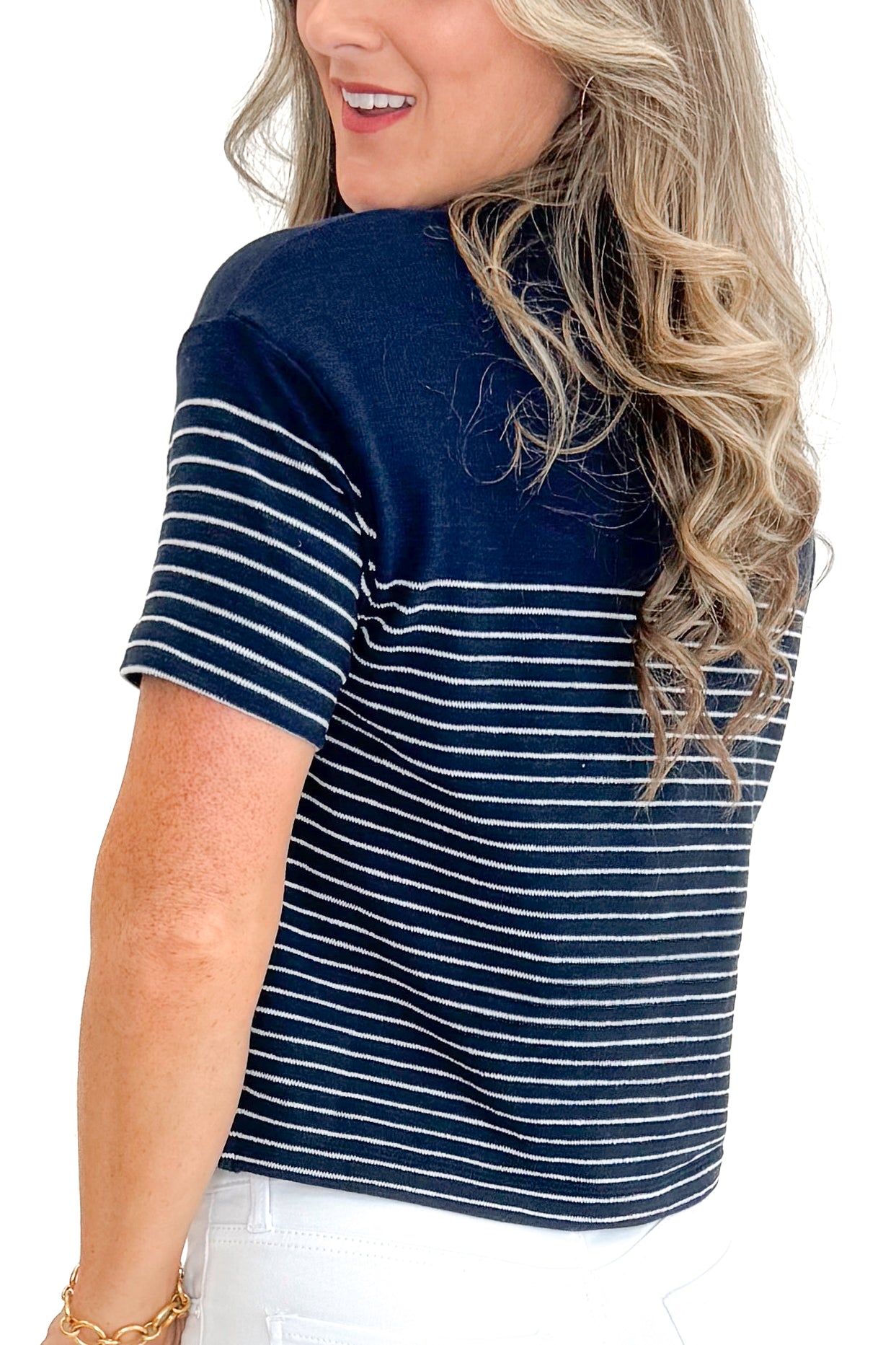 Side detail view of woman wearing Eclipse Harbor Striped Shirt by Z Supply with jeans against white studio background.