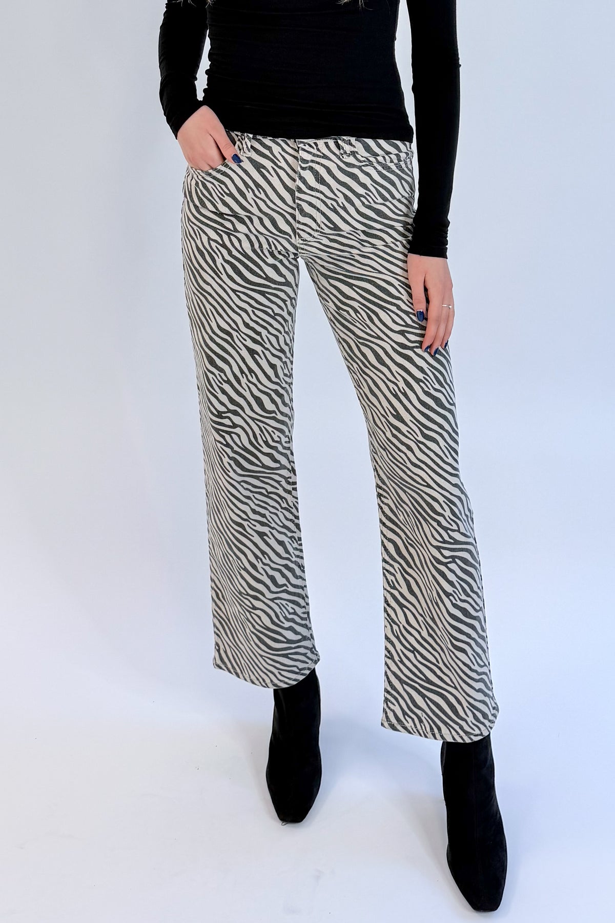 Front view of woman wearing Swagger Boutique’s top with Zebra Straight Leg Jeans by Just Black Denim against white studio background.